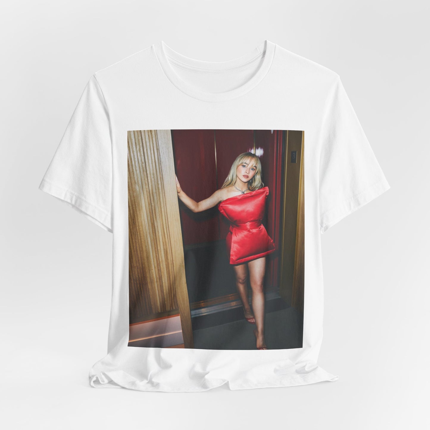 A black graphic t-shirt featuring a graphic of Sabrina Carpenter with 'hot pop vibes'.