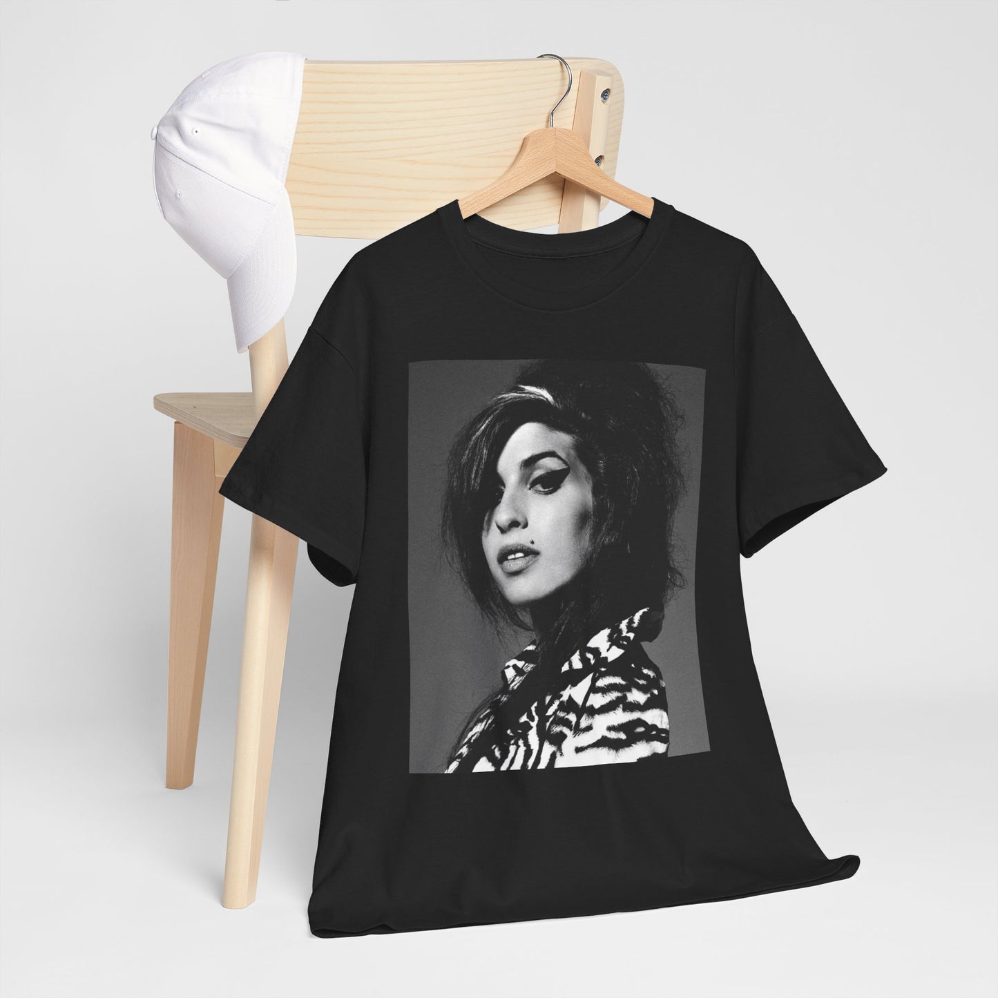 A black graphic t-shirt featuring a black and white portrait photo of Amy Winehouse from 2006, showing her with her signature beehive.