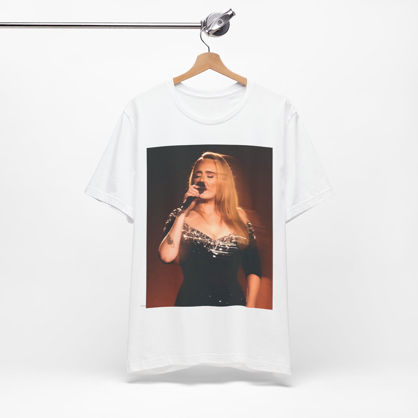 A black graphic t-shirt featuring a stylized image or photo of Adele related to her Las Vegas residency, possibly with elements of stage lighting or show branding.