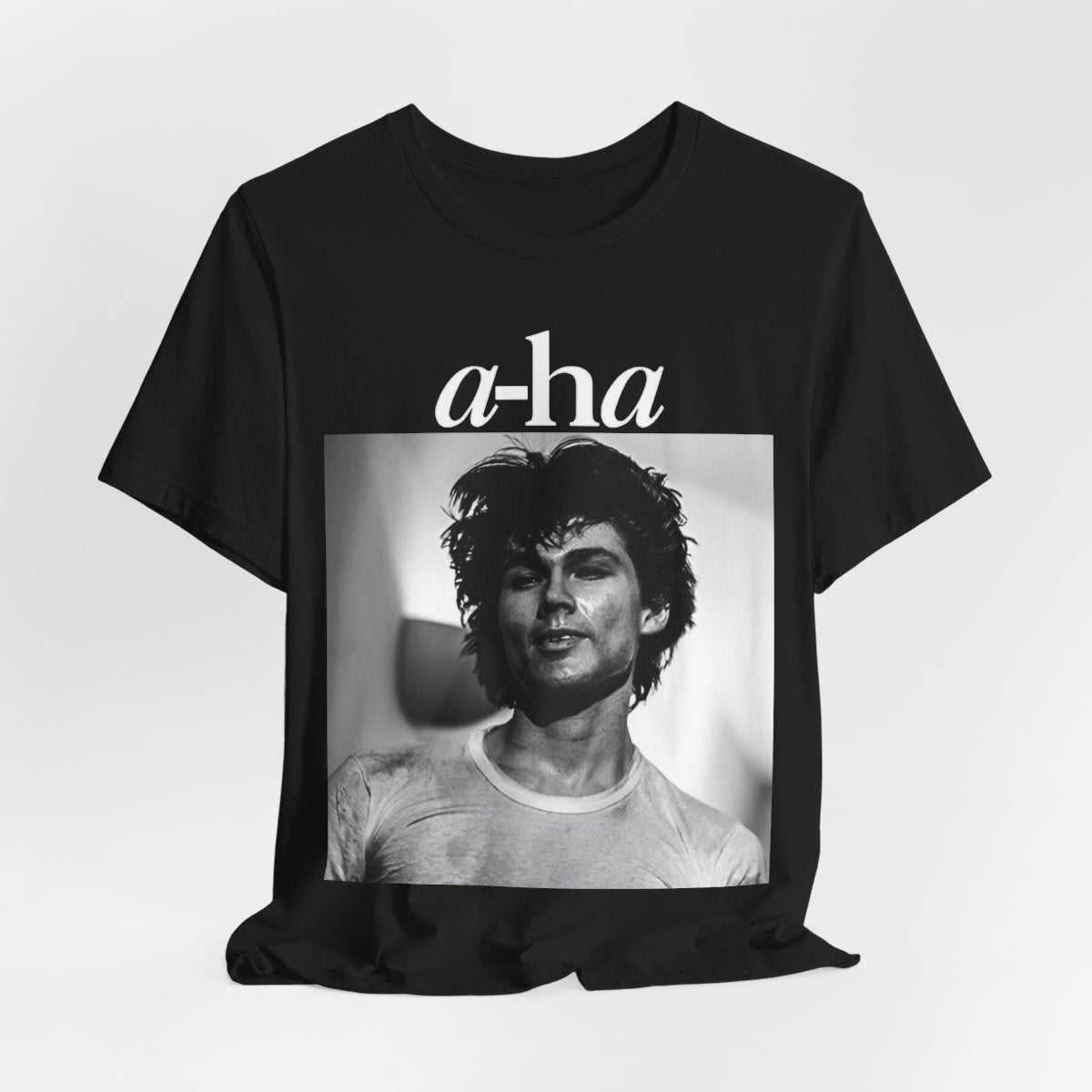A black graphic t-shirt featuring the A-HA logo integrated with a black and white photo of the band members.