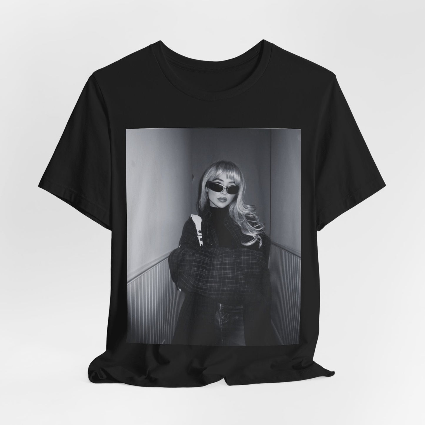 A black graphic t-shirt featuring a black and white glam pop diva graphic of Sabrina Carpenter.