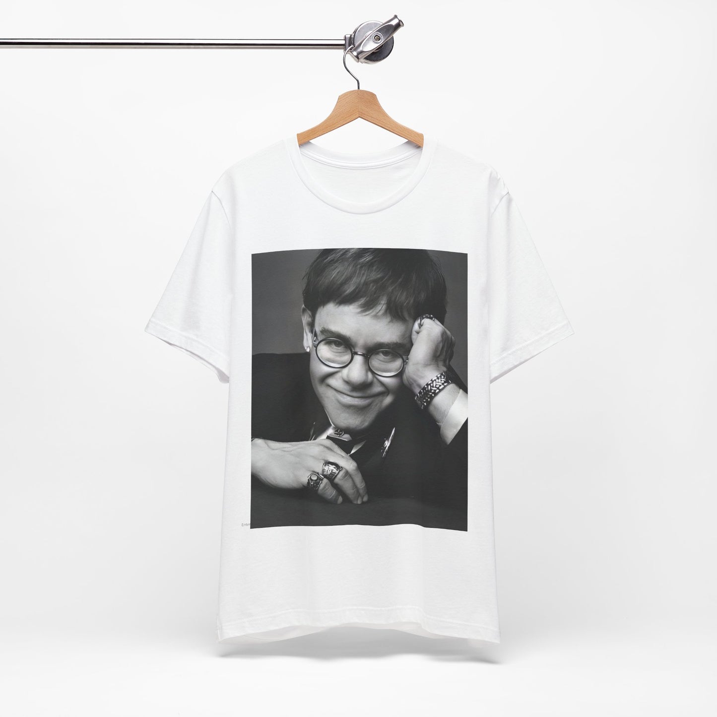 A black graphic t-shirt featuring a retro black and white photo portrait of Elton John.