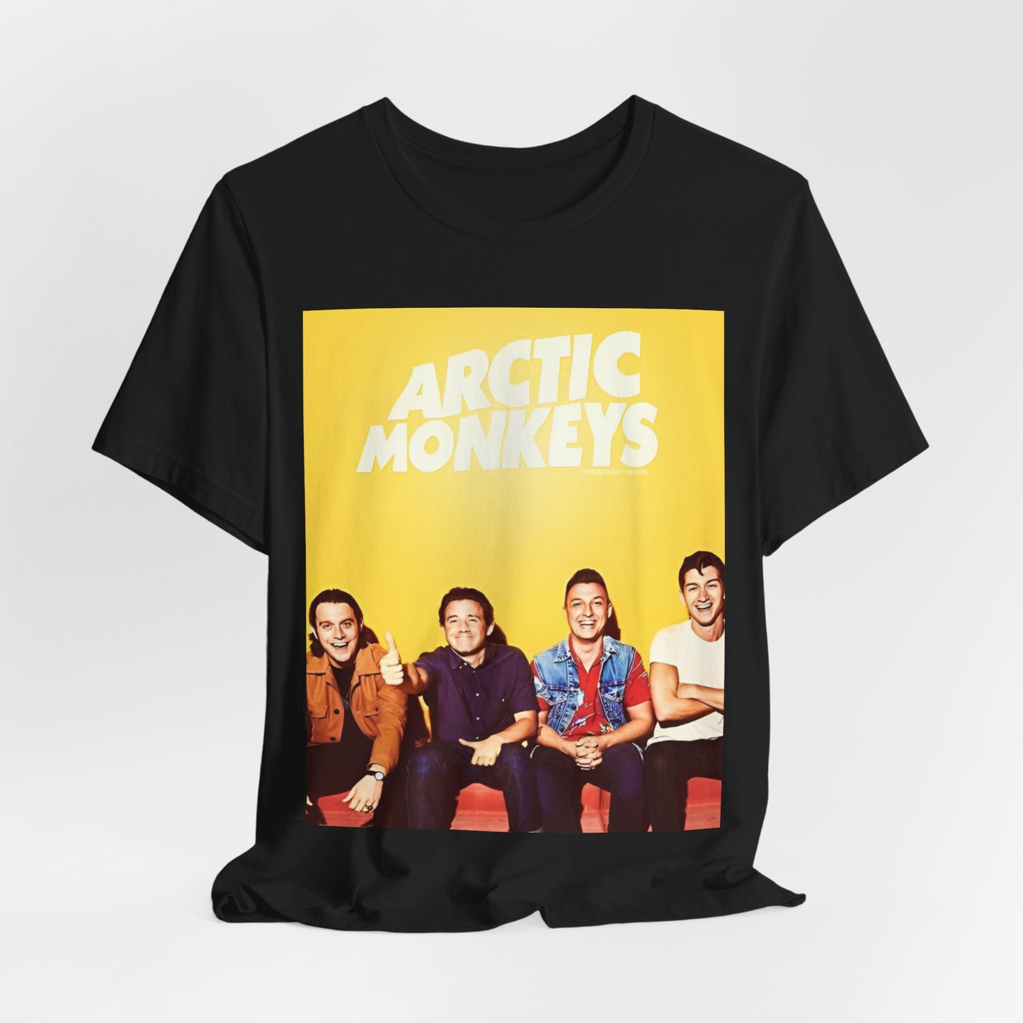 A black graphic t-shirt featuring a bold, vintage-style graphic for the Arctic Monkeys, possibly with abstract elements or stylized band imagery.