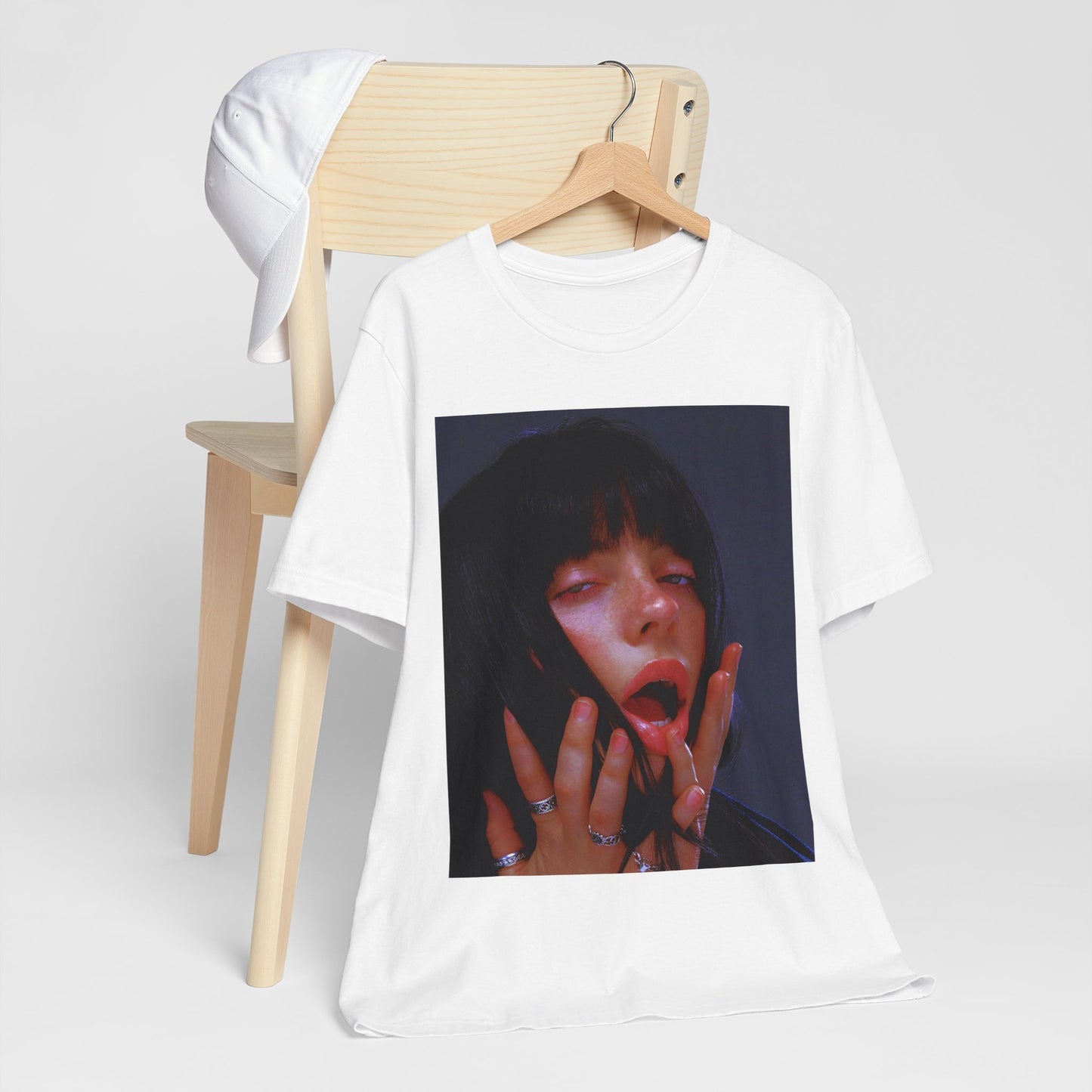 An intense, artistic photo of Billie Eilish with a bloody nose, conveying a sense of raw power, printed on a graphic t-shirt.