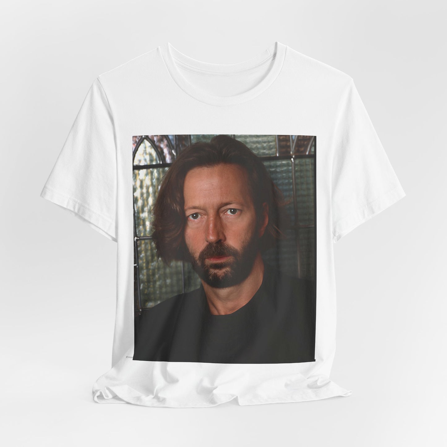 A black graphic t-shirt featuring a portrait graphic of Eric Clapton as a guitar god legend.
