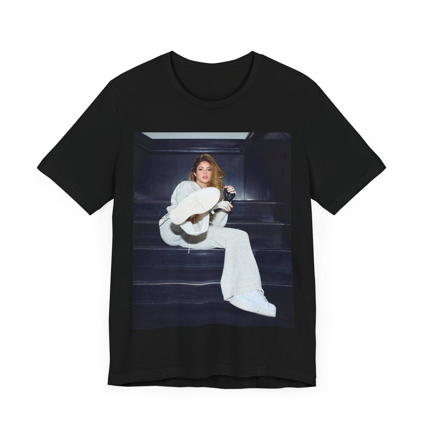 A black graphic t-shirt featuring a vintage Latin pop icon graphic of Shakira.