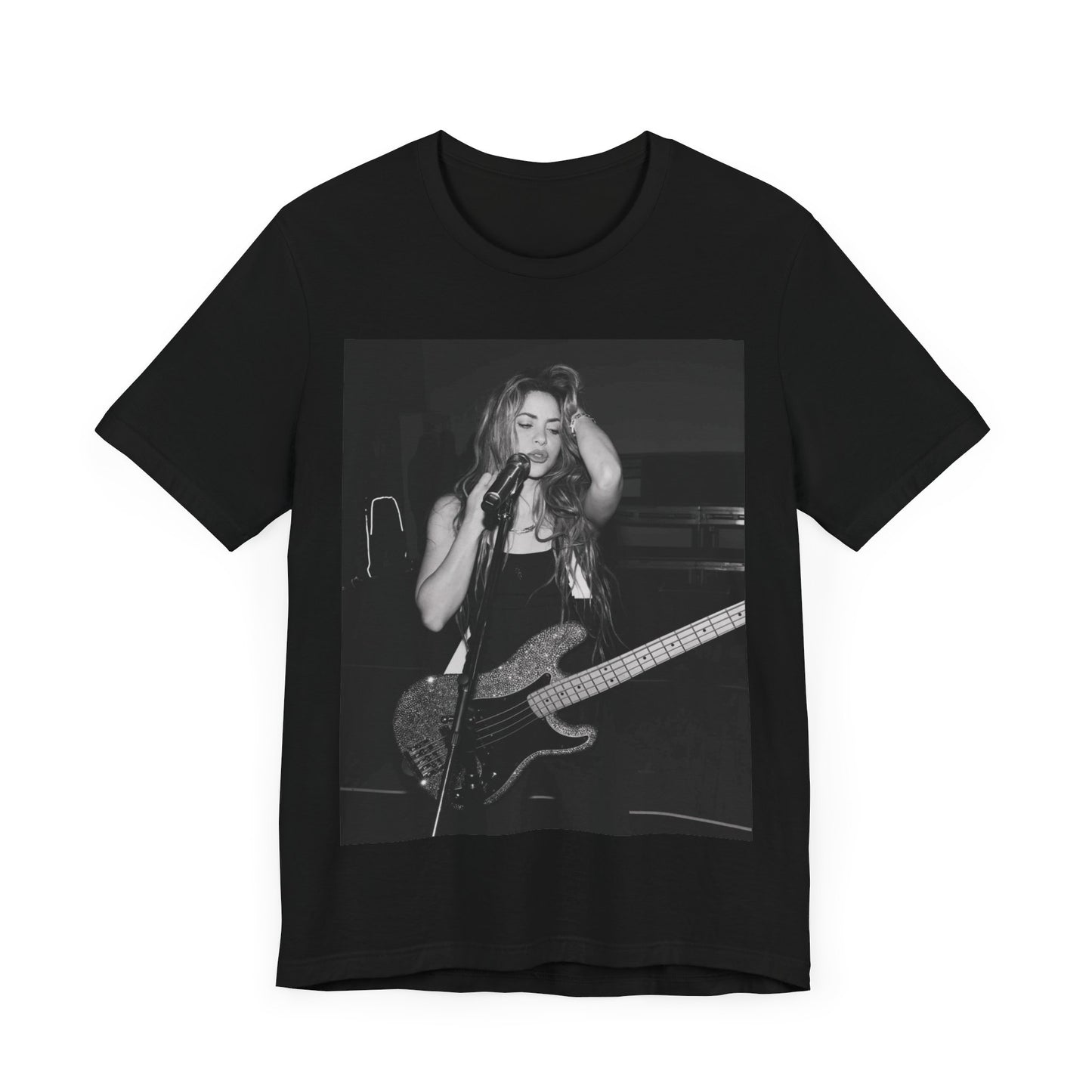 A black graphic t-shirt featuring a black and white graphic or photo of Shakira playing guitar live.