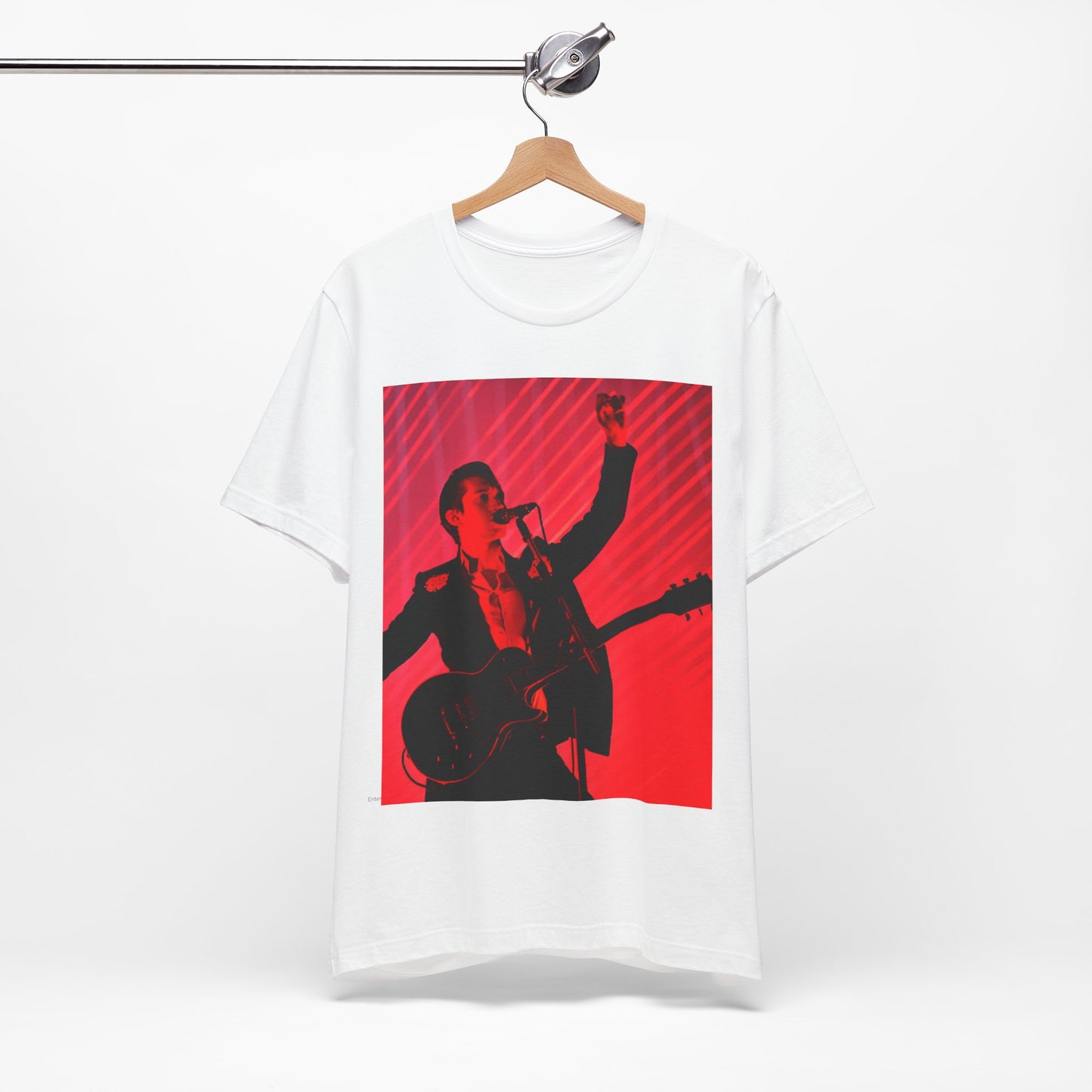 A black graphic t-shirt featuring a dynamic graphic or photo of Arctic Monkeys performing live in concert.