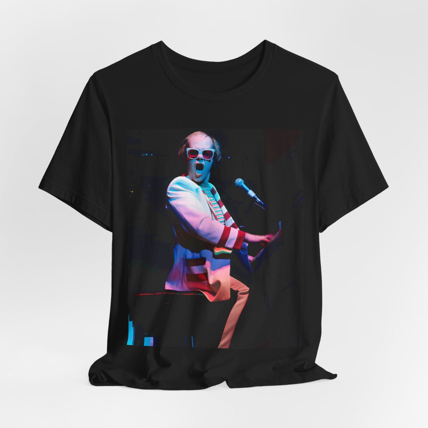 A black graphic t-shirt featuring a photo of Elton John performing live on stage at his piano.