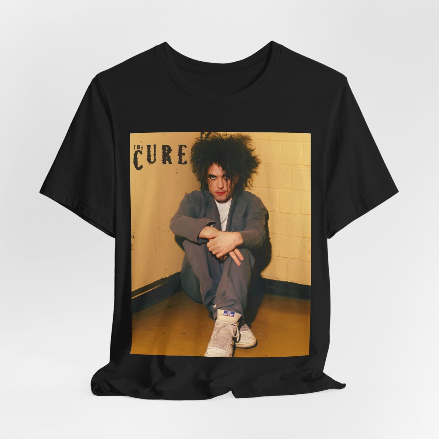 A black graphic t-shirt featuring a bold goth rock superstar graphic of The Cure.