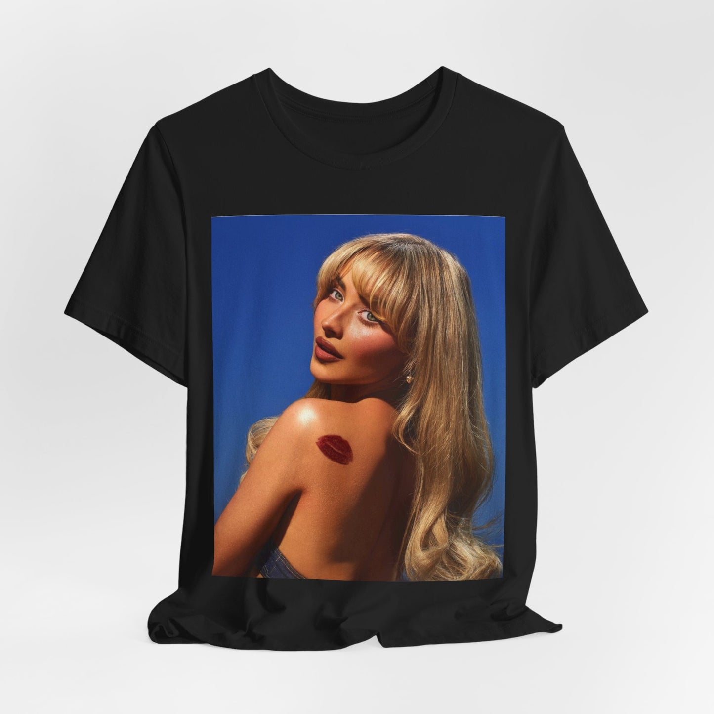 A black graphic t-shirt featuring a stylized graphic of Sabrina Carpenter, designed with a modern pop aesthetic.