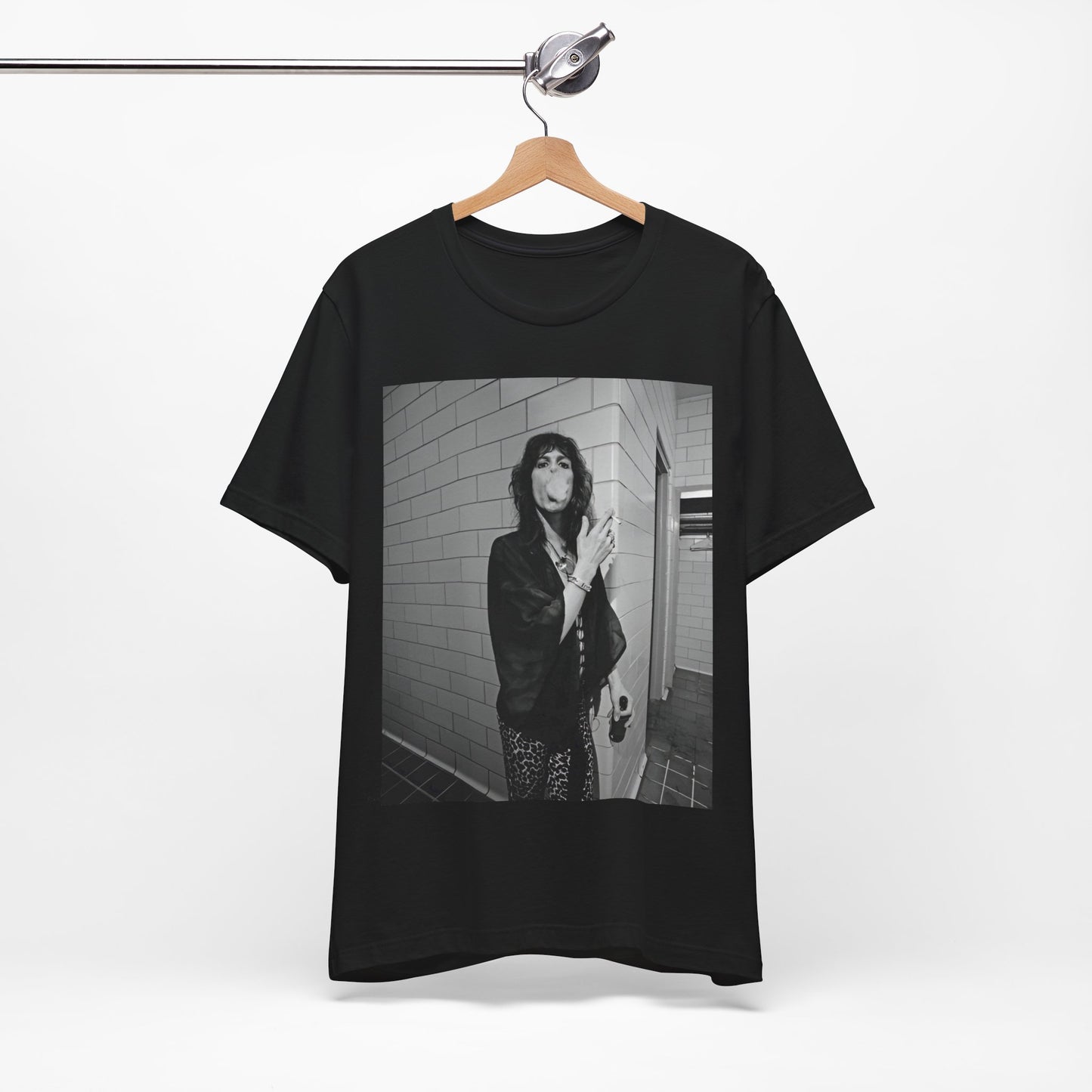 A black graphic t-shirt featuring a retro 70s photo of Aerosmith band members in a backstage setting, showing a candid moment.