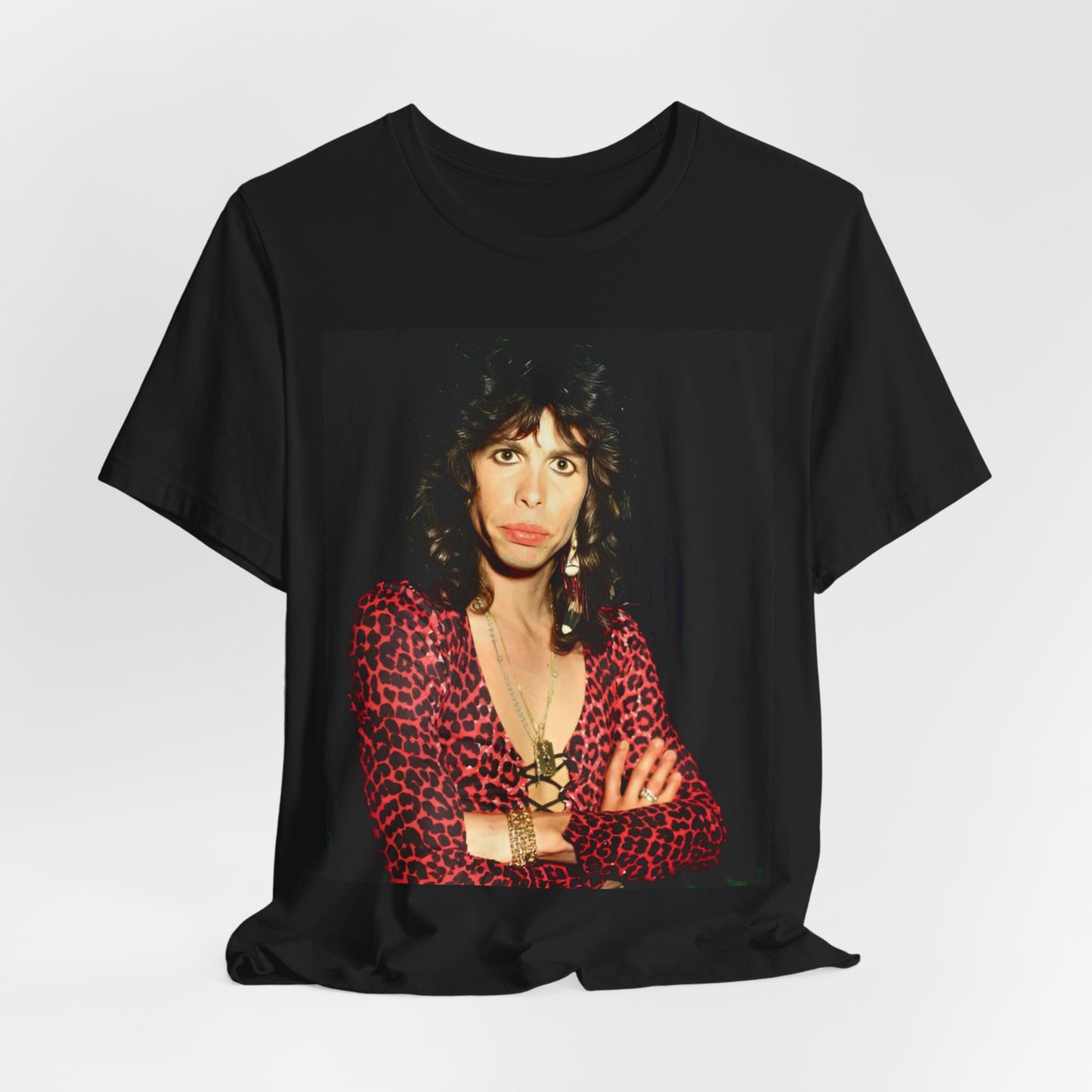 A black graphic t-shirt featuring a vintage 70s-inspired design with Aerosmith branding, incorporating a prominent leopard print pattern.