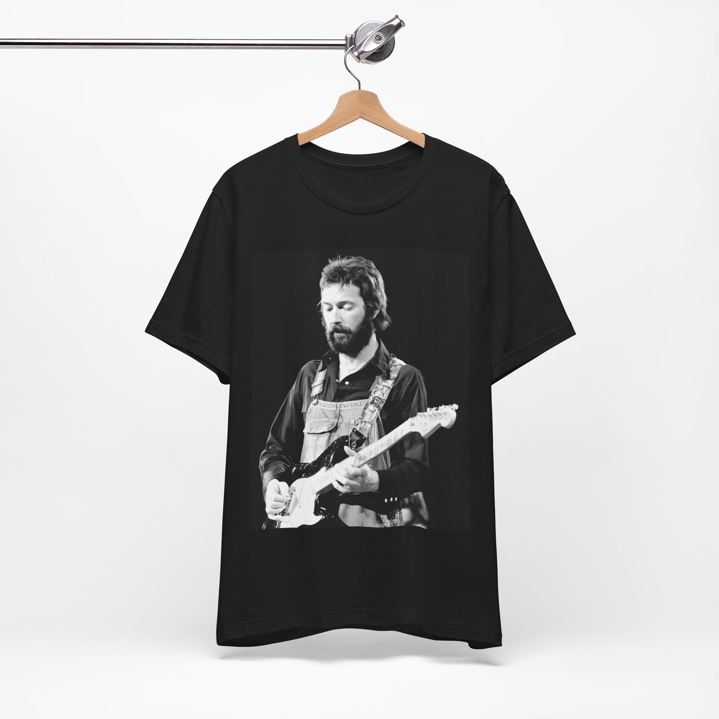 A black graphic t-shirt featuring a graphic or photo of Eric Clapton performing live on stage with his guitar.