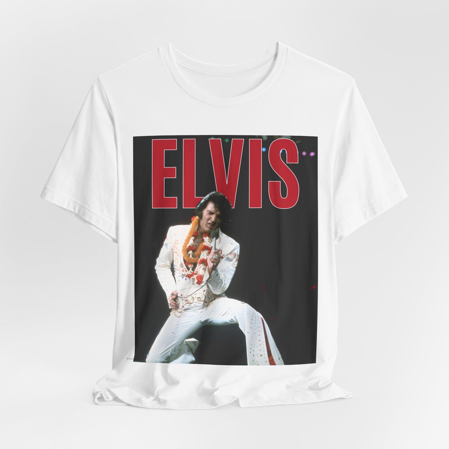 A black graphic t-shirt featuring a glamorous graphic or photo of Elvis Presley on a Las Vegas stage.