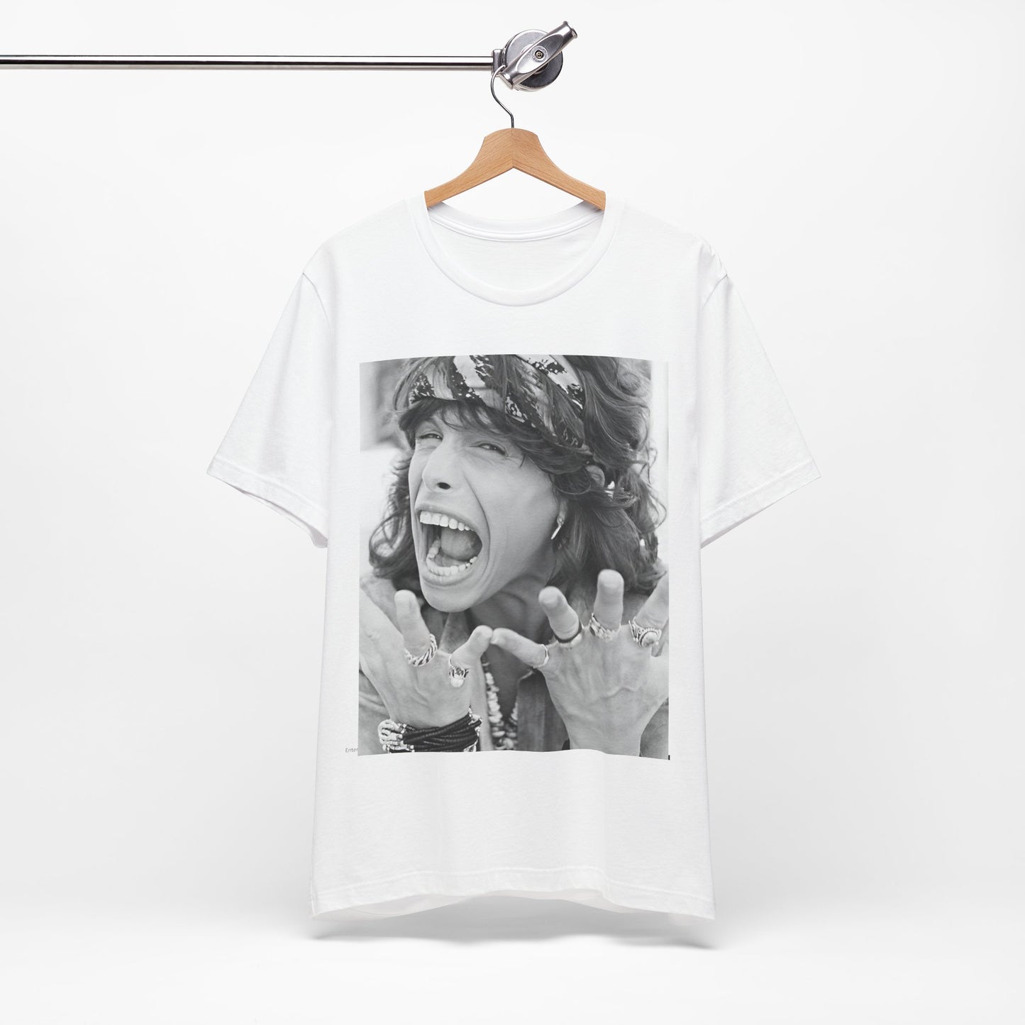 A black graphic t-shirt featuring a candid, dynamic photo of Aerosmith band members on tour in the 1970s, possibly showing action or interaction on stage or backstage.
