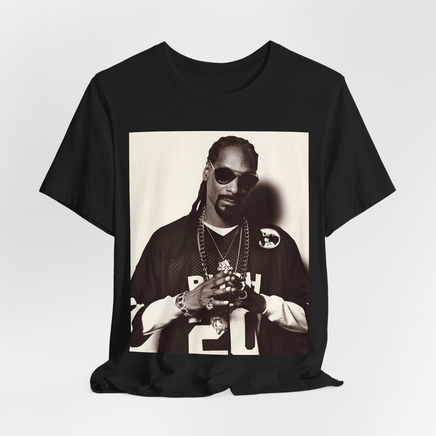 A black graphic t-shirt featuring a black and white, monochrome graphic or photo of Snoop Dogg in an OG style.