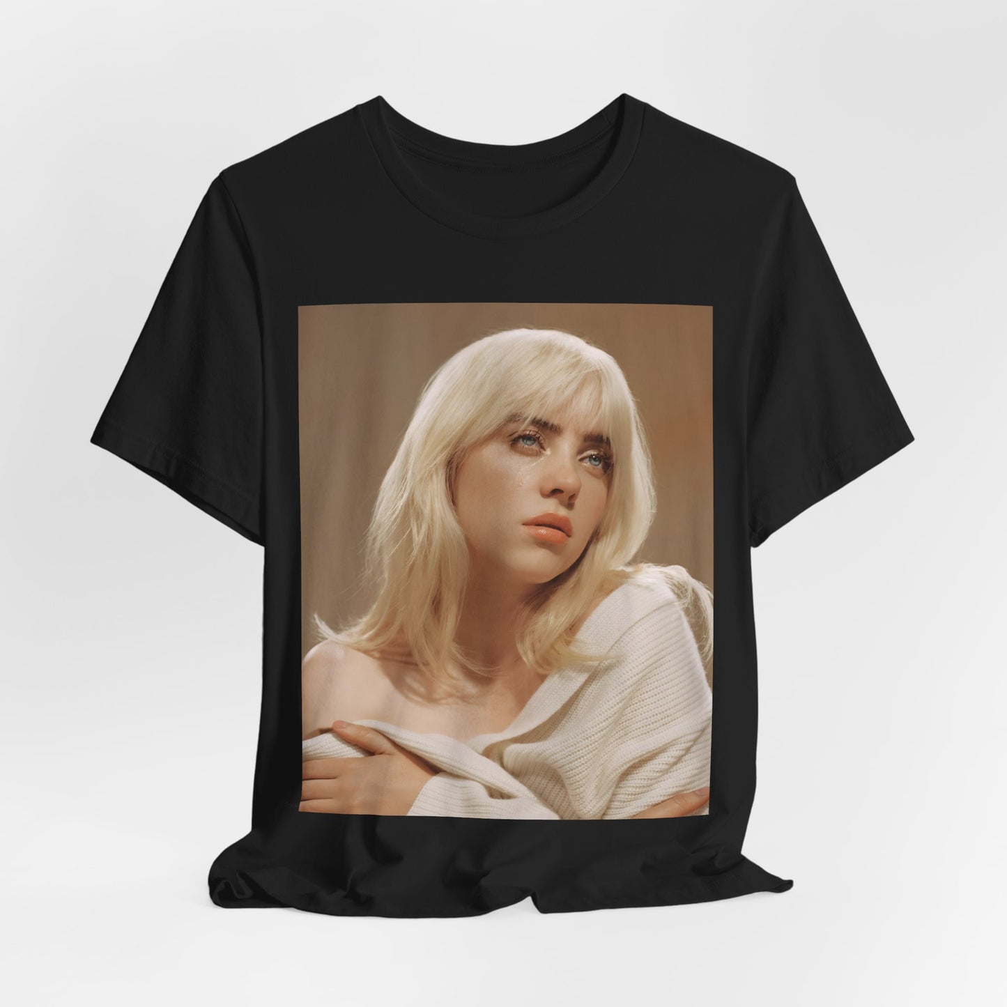 The iconic visual of Billie Eilish with black tears streaming down her face from the 'when the party's over' music video, printed on a t-shirt.