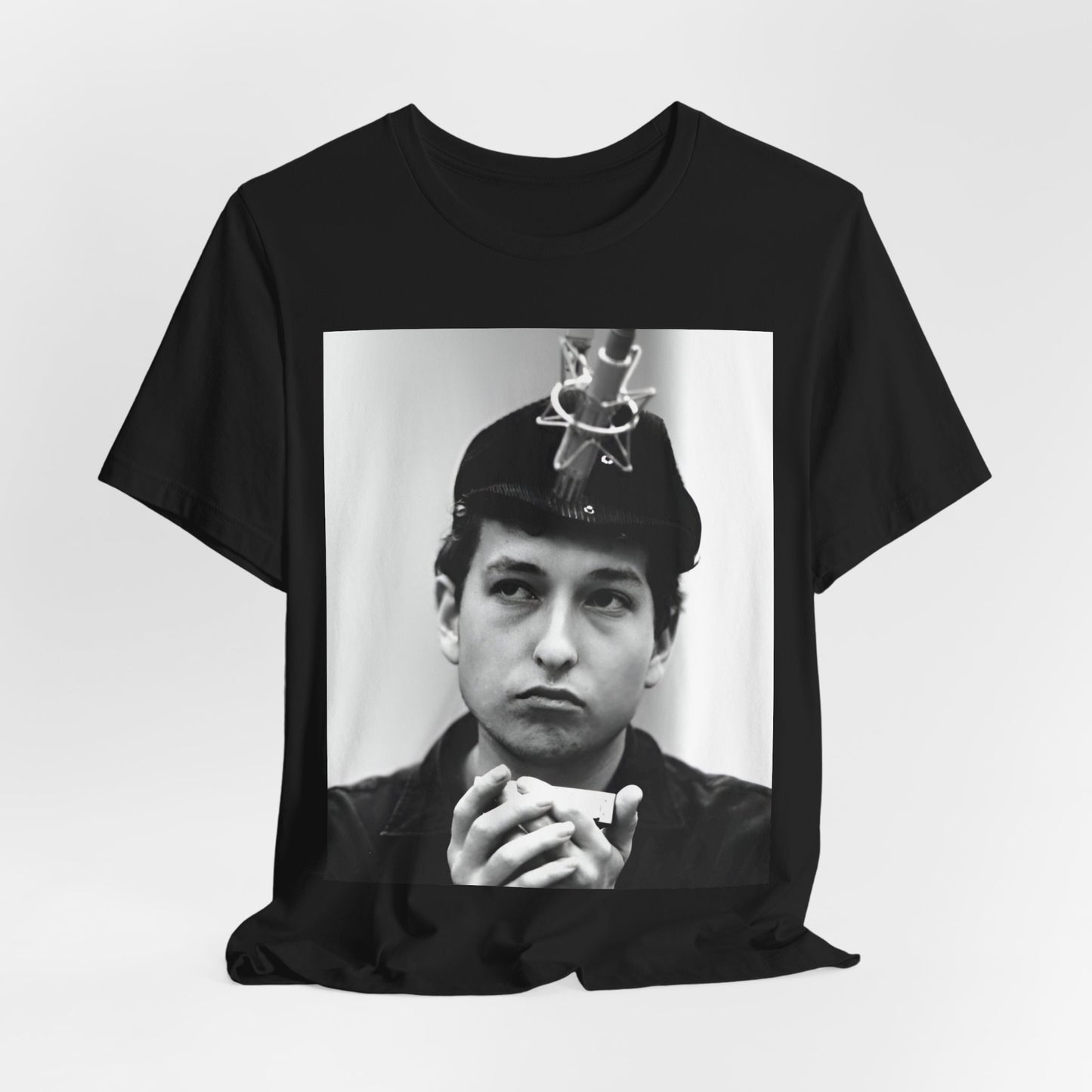 A black graphic t-shirt featuring a graphic of Bob Dylan in an acoustic session setting, possibly with his guitar.