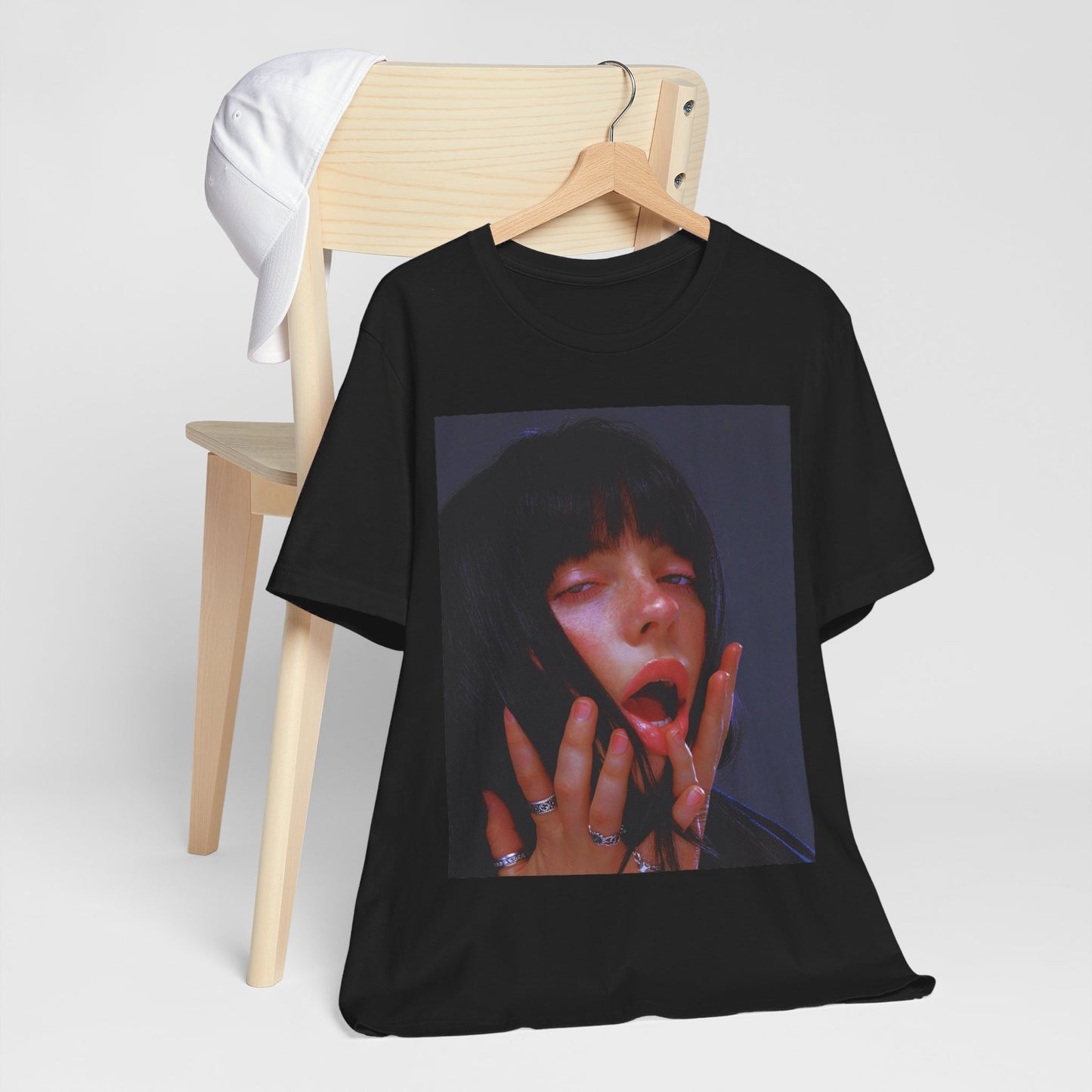 An intense, artistic photo of Billie Eilish with a bloody nose, conveying a sense of raw power, printed on a graphic t-shirt.