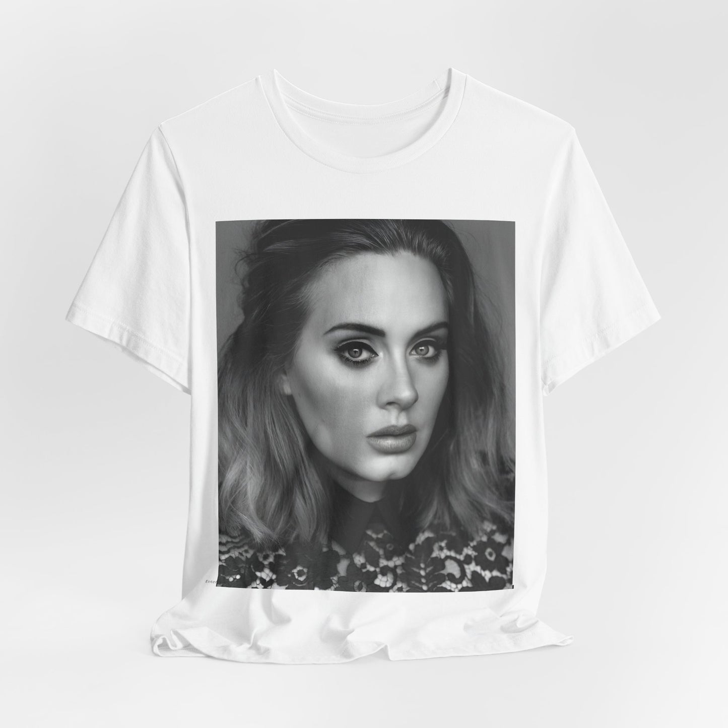 A black graphic t-shirt featuring a classic black and white, monochrome portrait of Adele, showing her with a serene or thoughtful expression.