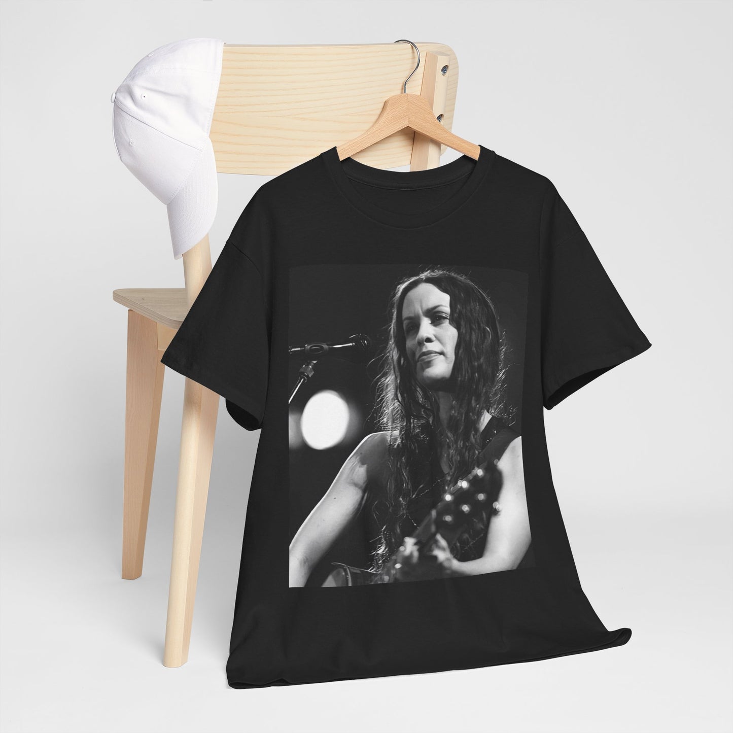 A black graphic t-shirt featuring a 90s-style graphic of Alanis Morissette playing a guitar, with a dynamic expression.