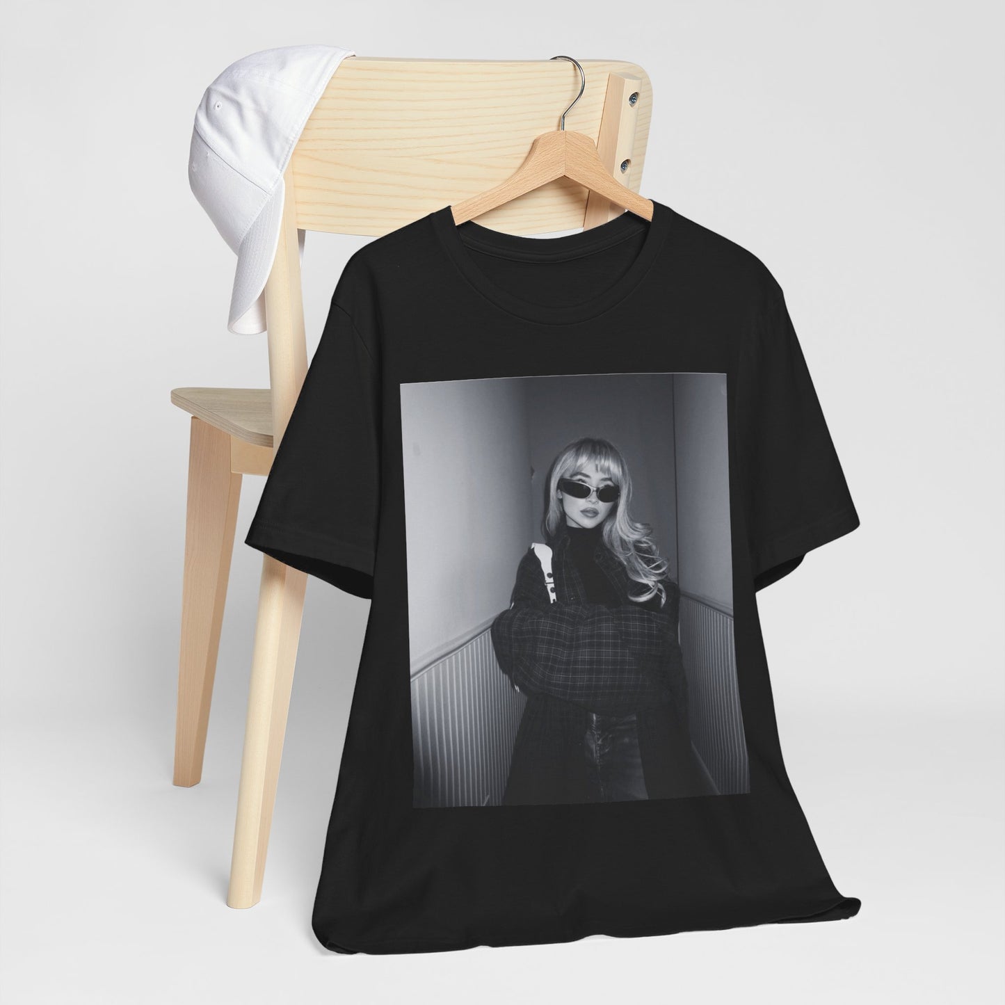 A black graphic t-shirt featuring a black and white glam pop diva graphic of Sabrina Carpenter.