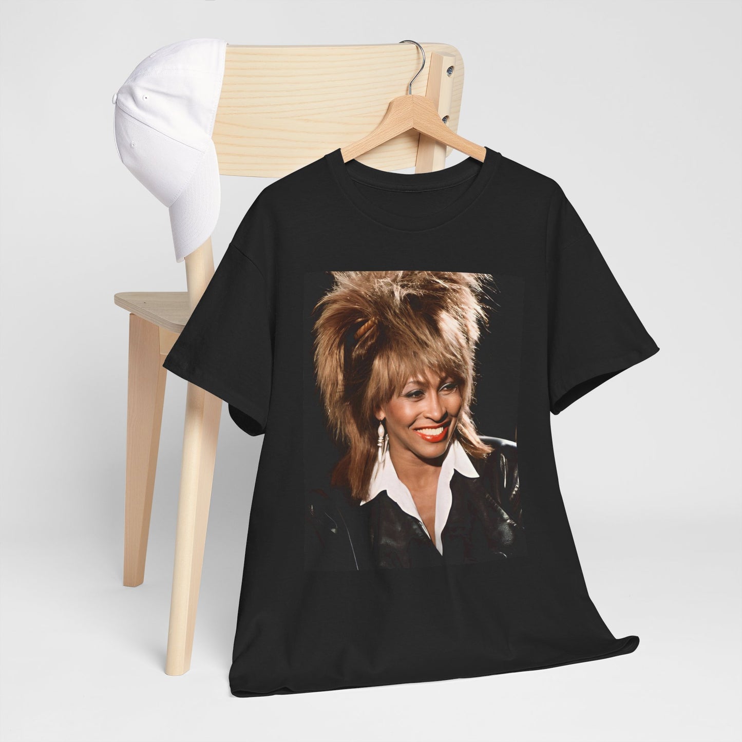 A black graphic t-shirt featuring a nostalgic graphic of Tina Turner as the Queen of Rock.