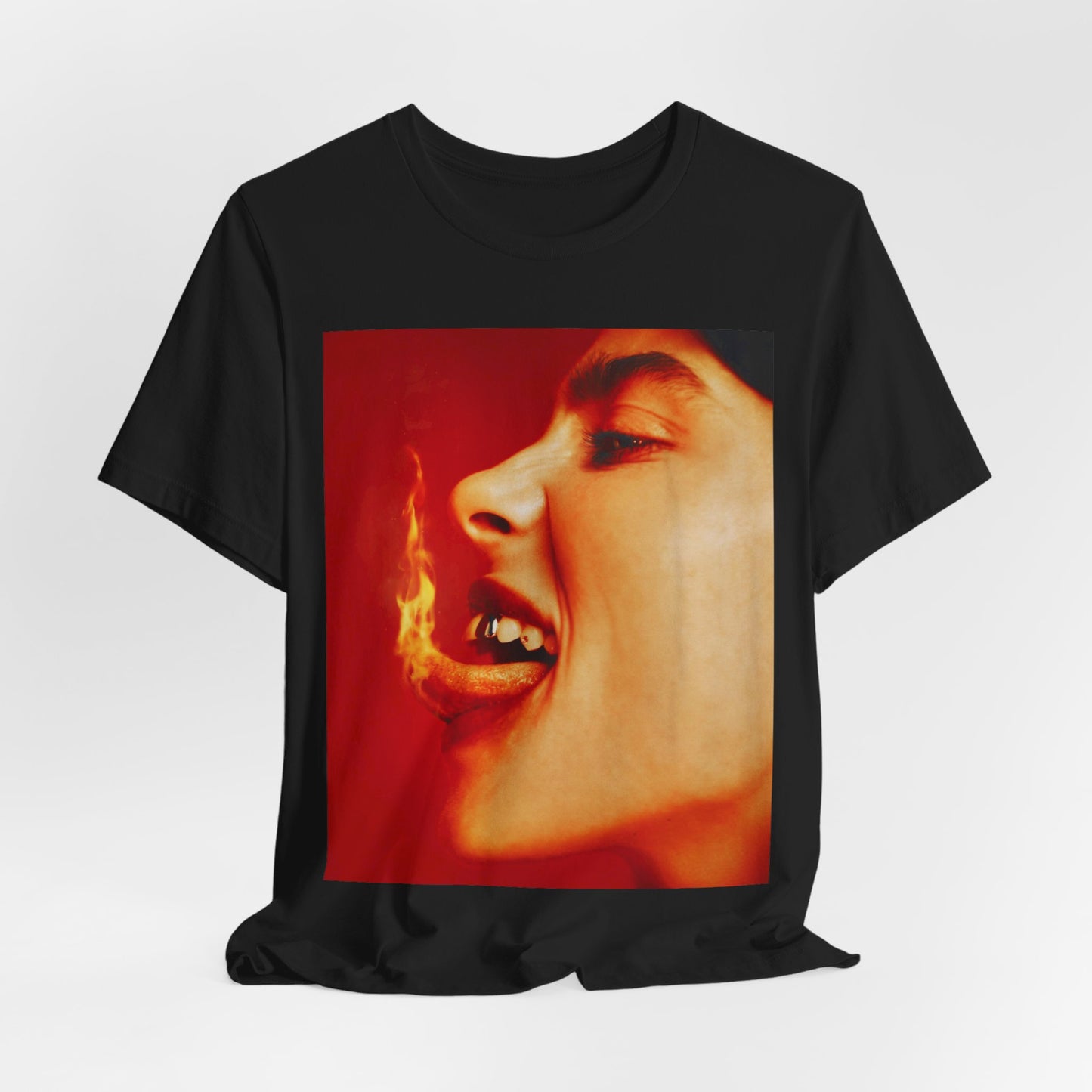 A close-up, red-toned photo of a face in profile with its mouth open and a live flame on the tongue, printed on a graphic t-shirt.