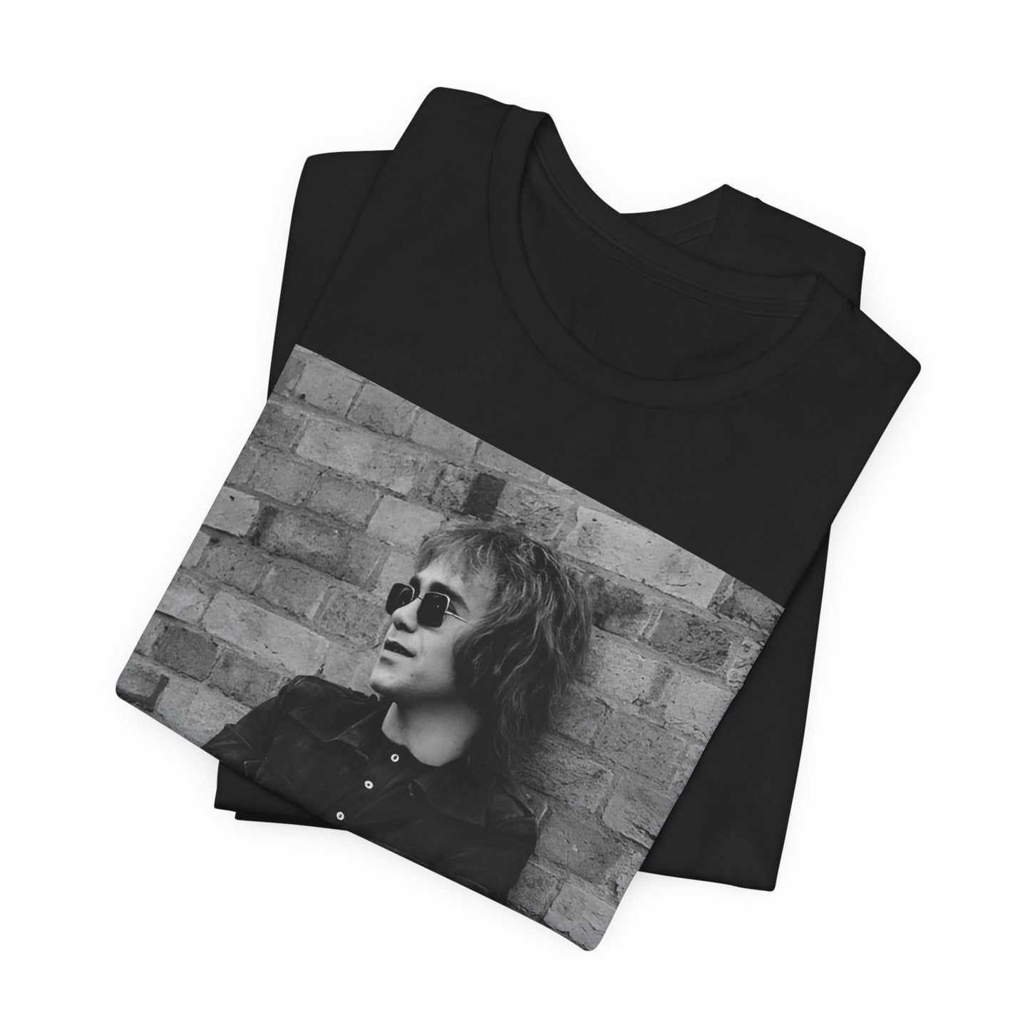 A black graphic t-shirt featuring a vintage graphic related to Elton John's 'Farewell Yellow Brick Road' tour.