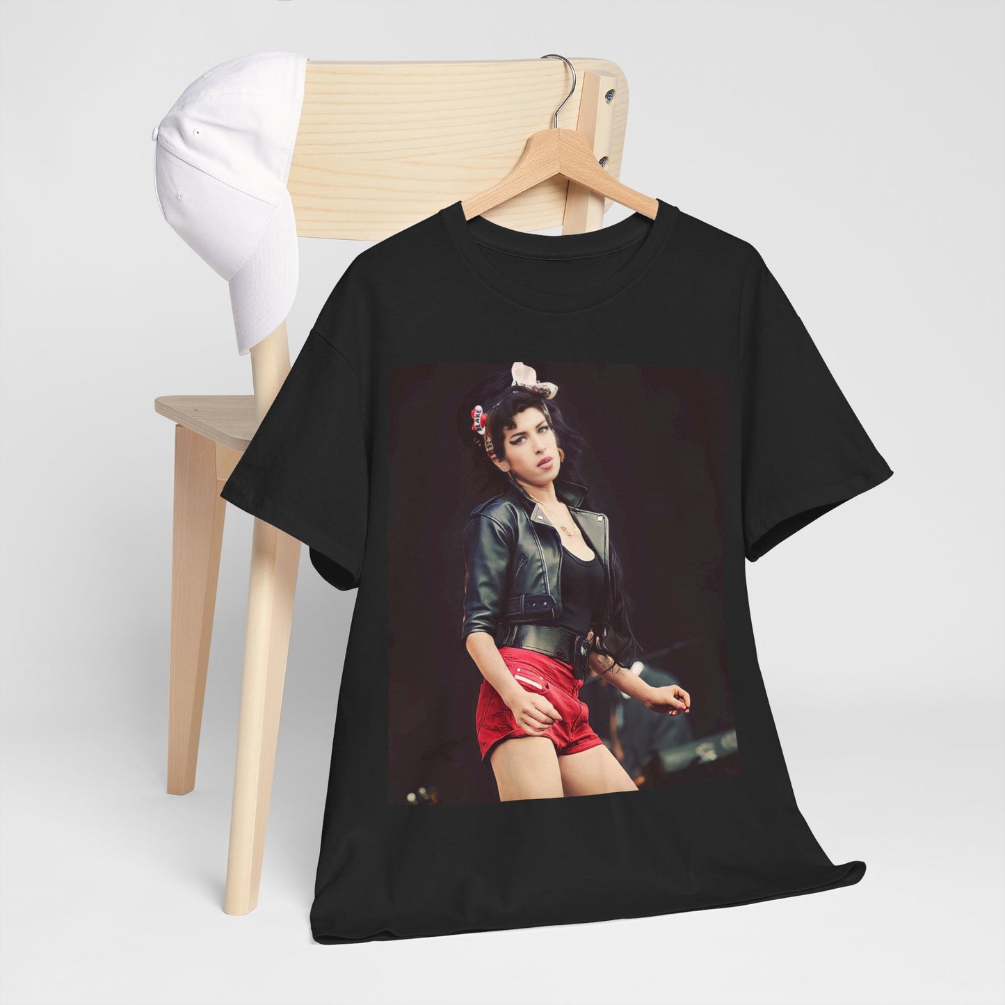 A black graphic t-shirt featuring a photo or illustration of Amy Winehouse on stage, with leather elements and a prominent red background or lighting.