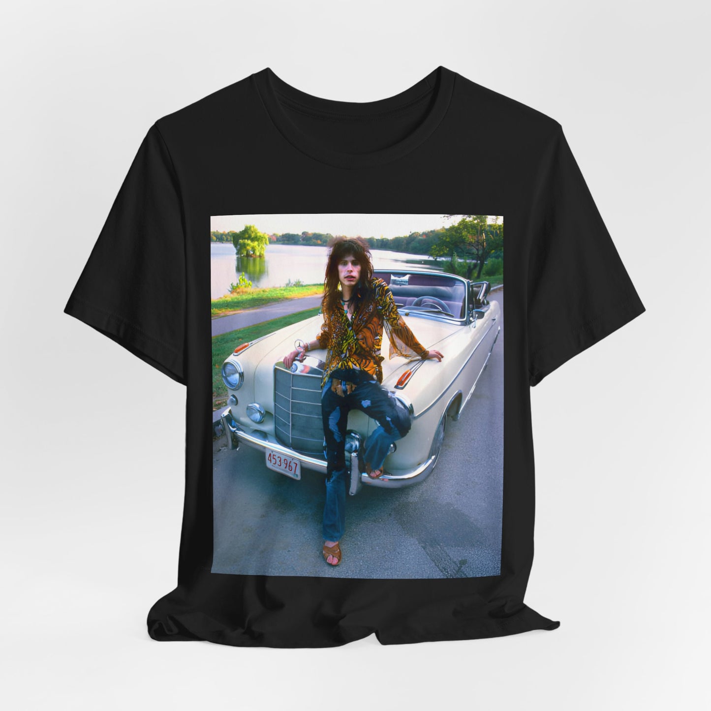 A black graphic t-shirt featuring a retro 70s photo of Aerosmith band members in a bohemian style, posing with a classic Mercedes car.