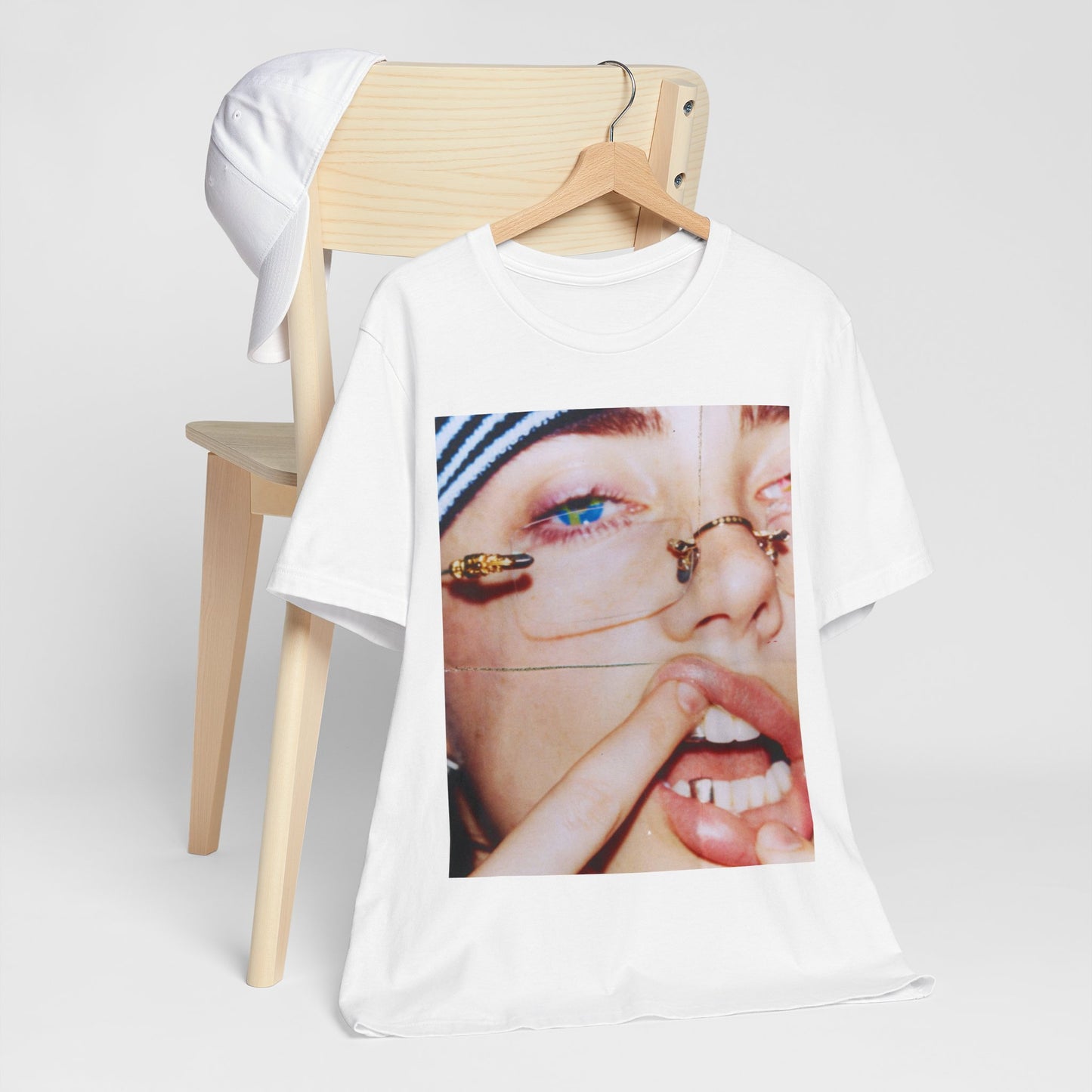 A direct, unfiltered, close-up portrait of Billie Eilish with dark hair looking straight at the camera, printed on a t-shirt.