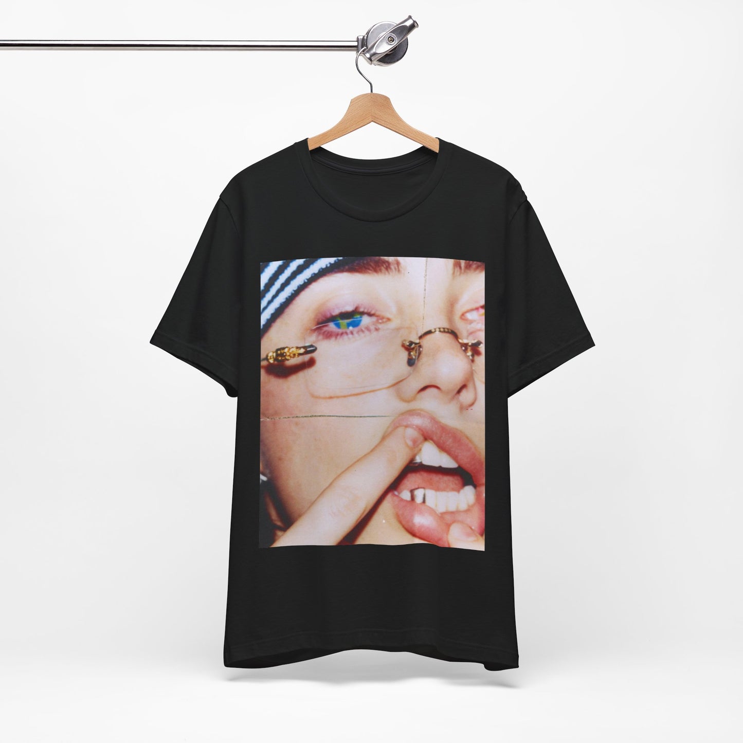 A direct, unfiltered, close-up portrait of Billie Eilish with dark hair looking straight at the camera, printed on a t-shirt.