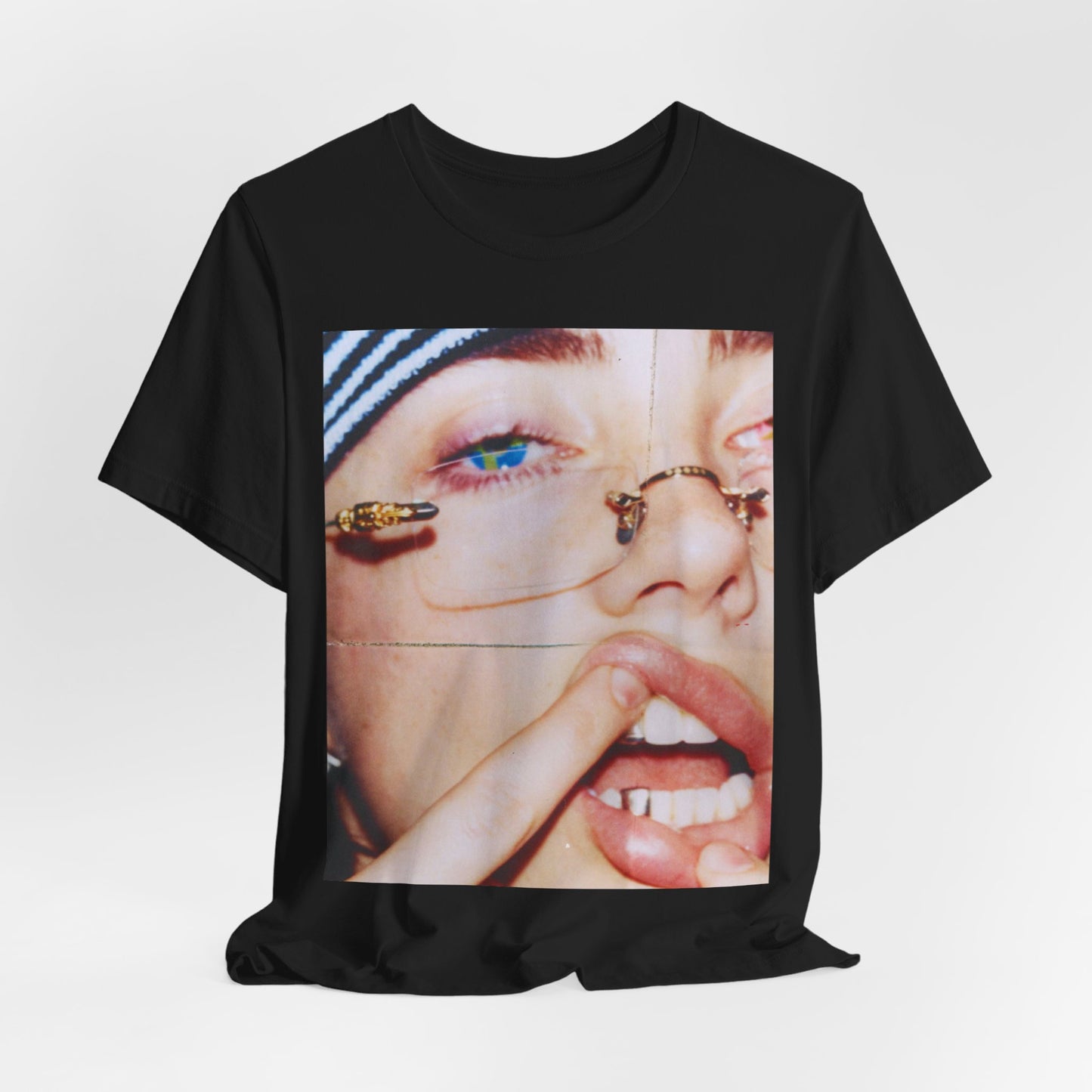 A direct, unfiltered, close-up portrait of Billie Eilish with dark hair looking straight at the camera, printed on a t-shirt.