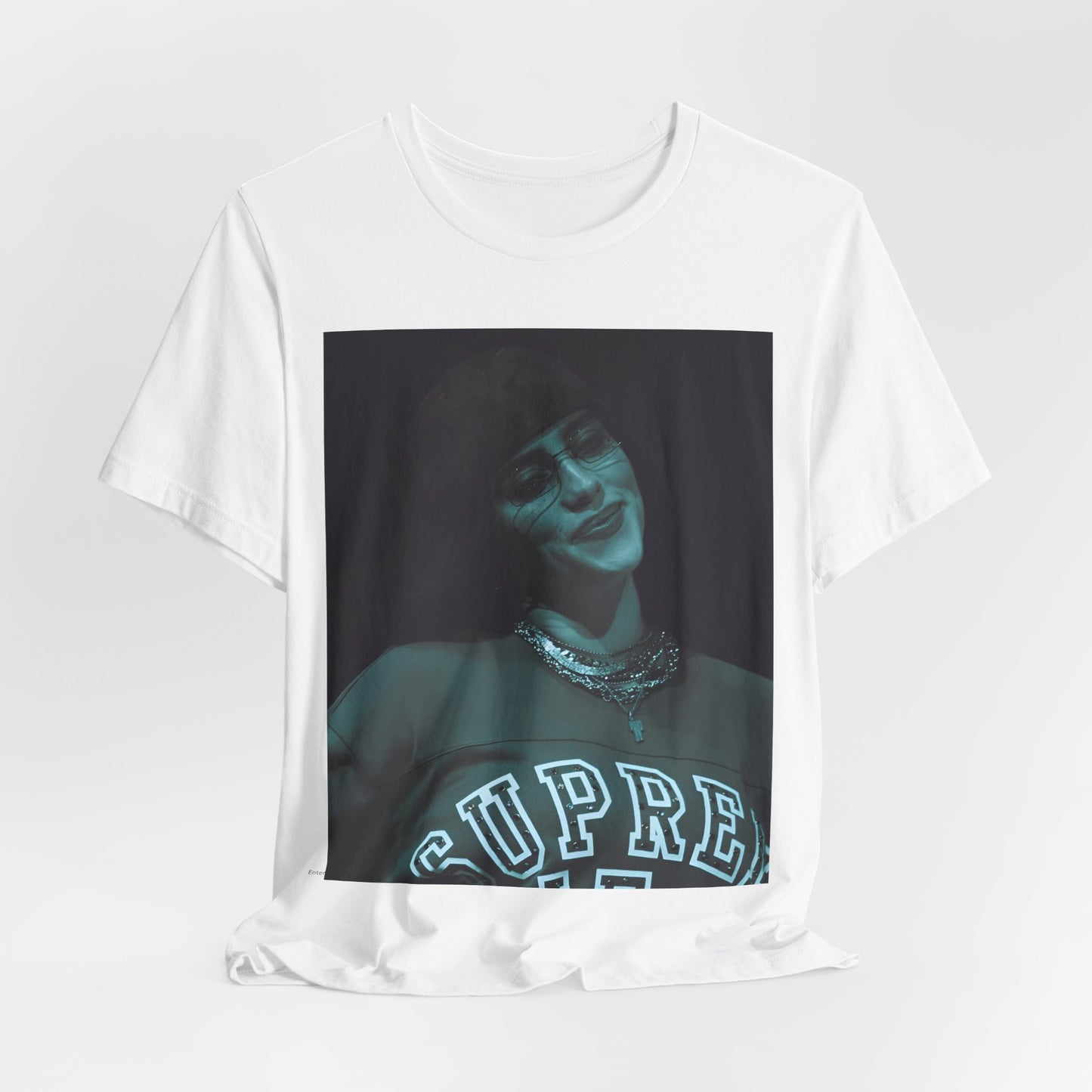 A powerful, close-up portrait of Billie Eilish with a direct and intense stare, printed on a graphic t-shirt.