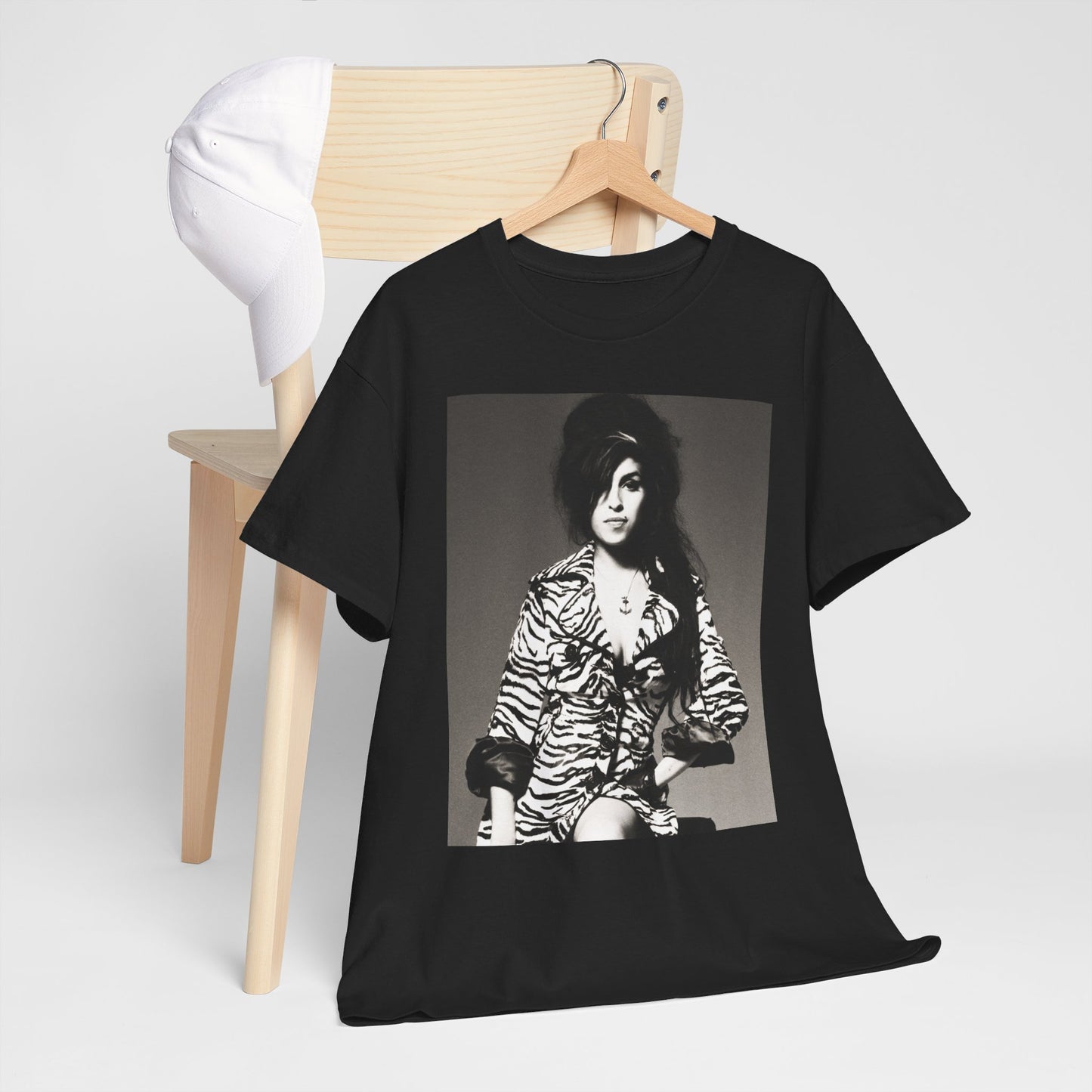 A black graphic t-shirt featuring a vintage black and white portrait of Amy Winehouse, showing her with her signature beehive and soulful expression.