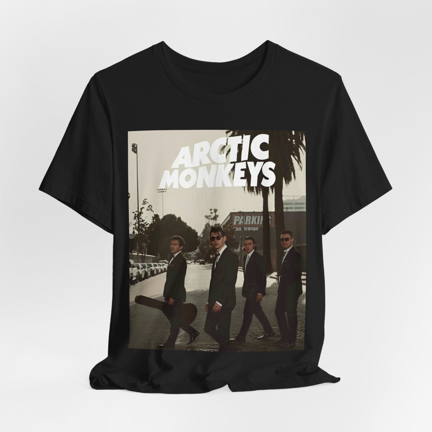 A black graphic t-shirt featuring Arctic Monkeys in a pose or setting similar to the iconic 'Abbey Road' album cover.
