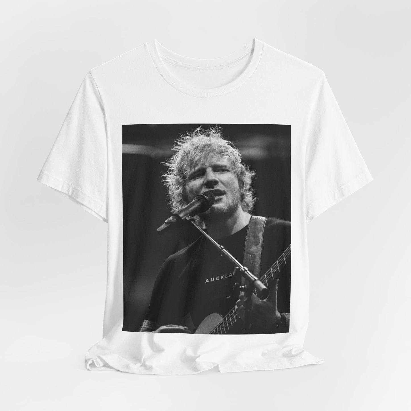 A black graphic t-shirt featuring a black and white photo of Ed Sheeran performing live.