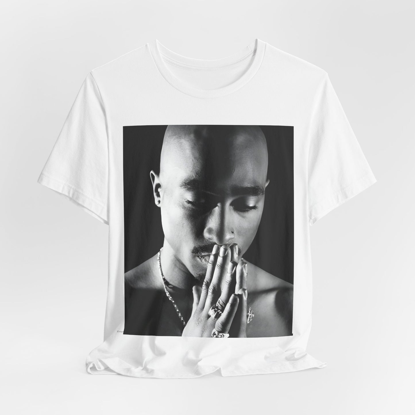 A black graphic t-shirt featuring a black and white streetwear rebel graphic of Tupac.