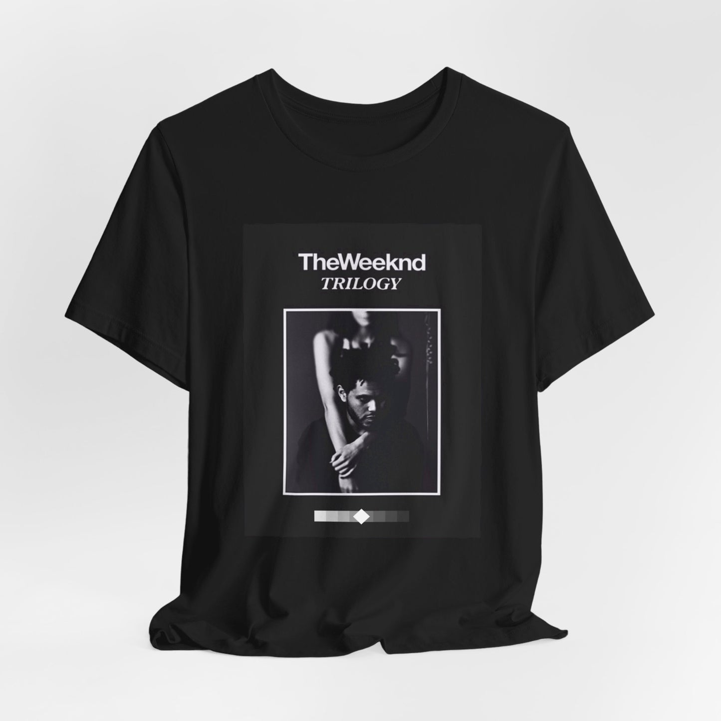 A black graphic t-shirt featuring a graphic related to The Weeknd's 'Trilogy' album.