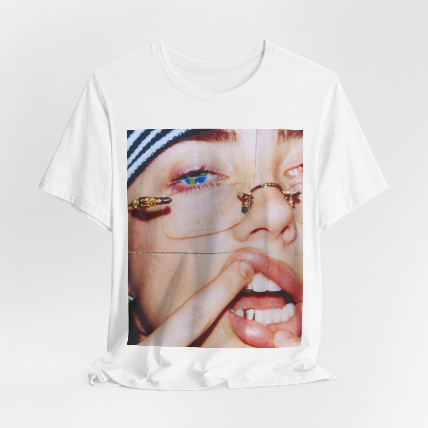 A direct, unfiltered, close-up portrait of Billie Eilish with dark hair looking straight at the camera, printed on a t-shirt.