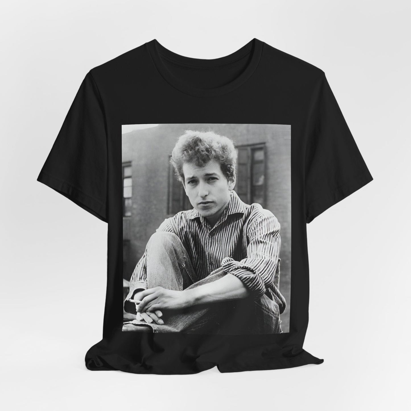 A black graphic t-shirt featuring a graphic of Bob Dylan from his 60s origins in folk music.