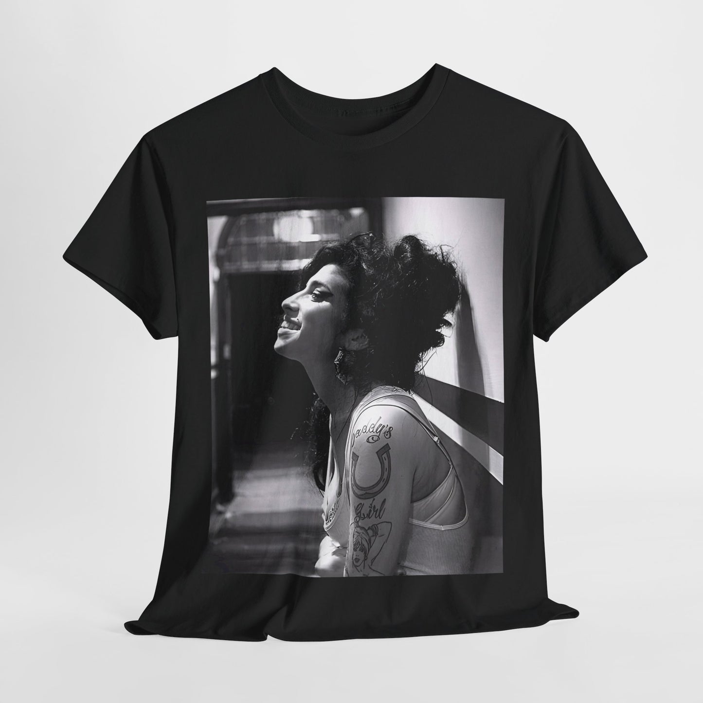 A black graphic t-shirt featuring a candid backstage photo of Amy Winehouse from her 'Back to Black' era, showing her in a relaxed setting.