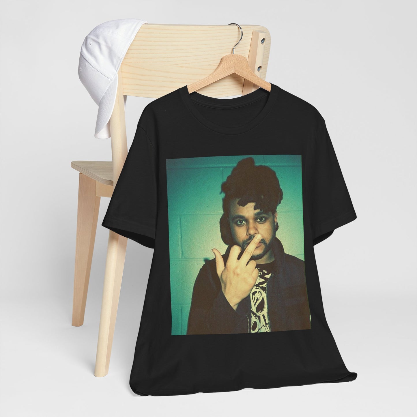 A black graphic t-shirt featuring a graphic of The Weeknd making the middle finger gesture.