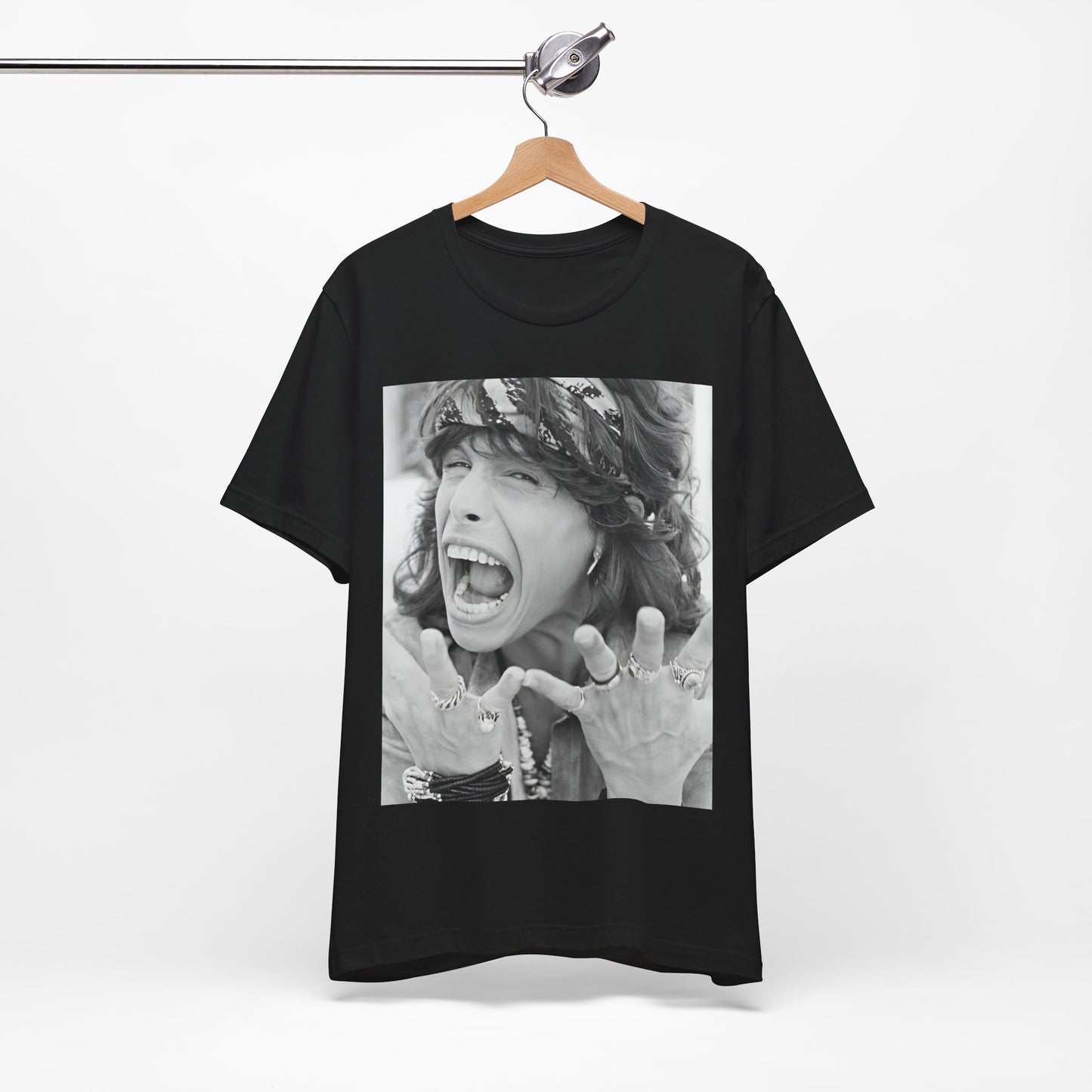 A black graphic t-shirt featuring a candid, dynamic photo of Aerosmith band members on tour in the 1970s, possibly showing action or interaction on stage or backstage.