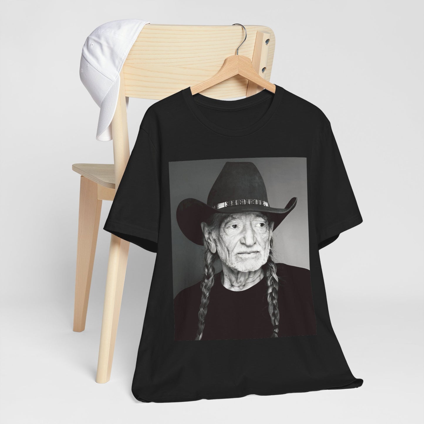 A black graphic t-shirt featuring a graphic of Willie Nelson with his iconic guitar 'Trigger'.