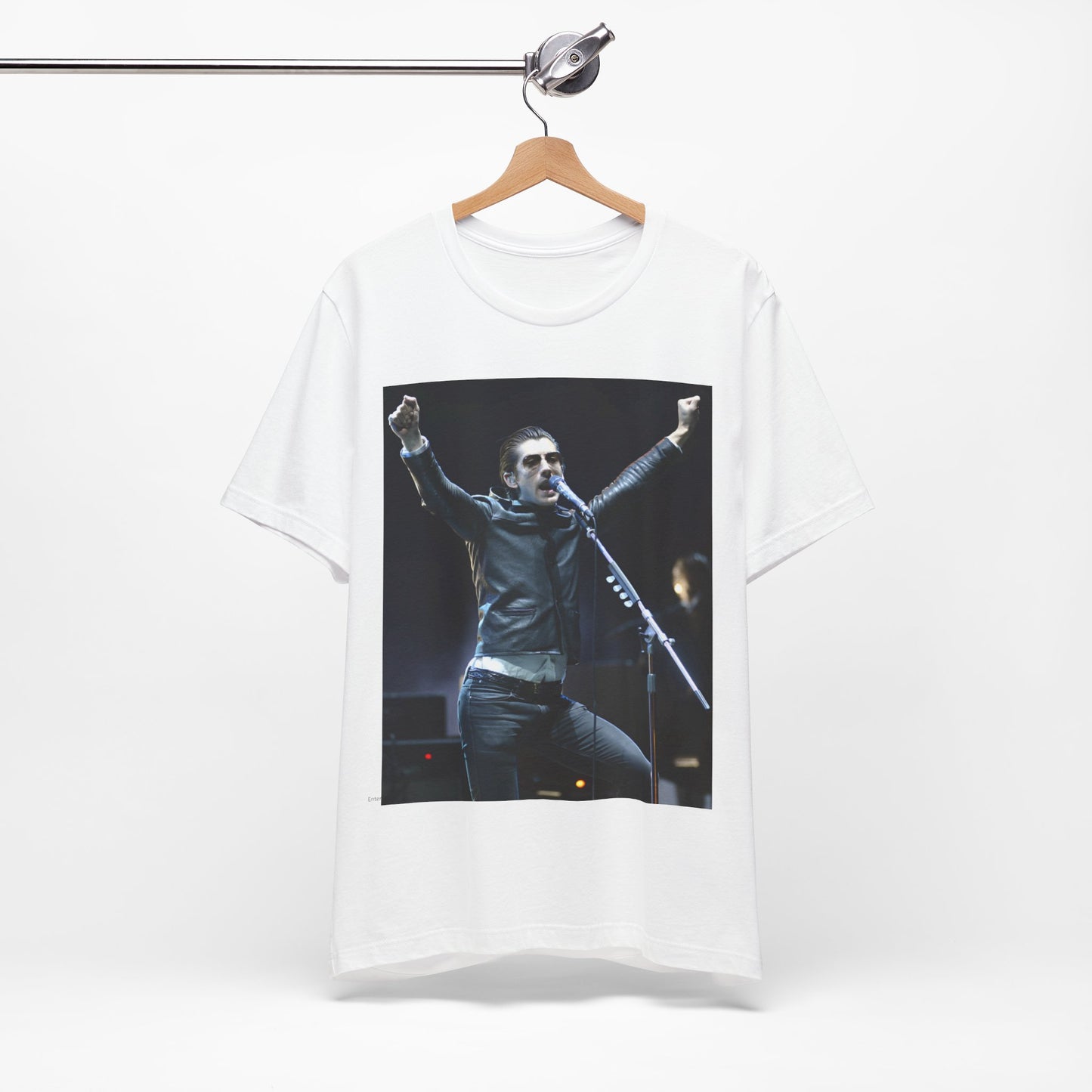 A black graphic t-shirt featuring a graphic or photo of Arctic Monkeys performing live on stage, with a Britpop aesthetic.
