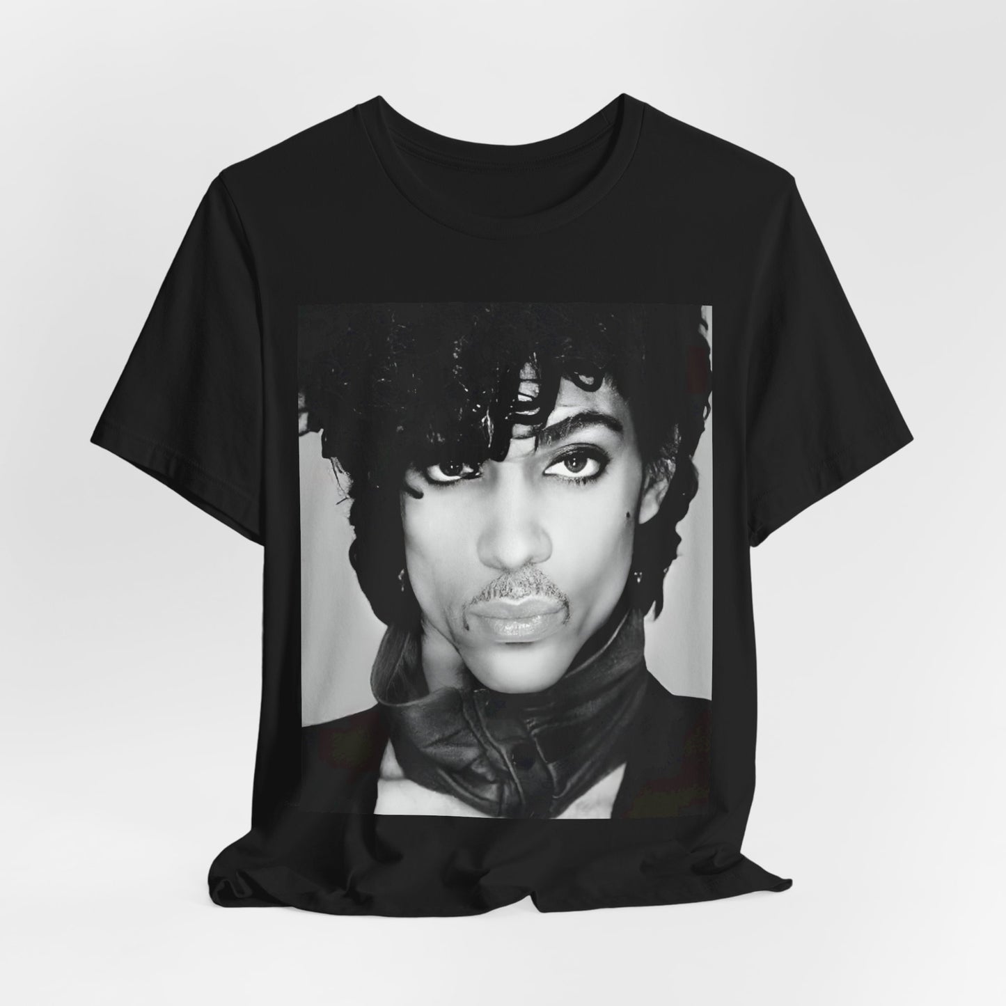 A black graphic t-shirt featuring a black and white photo portrait of Prince.