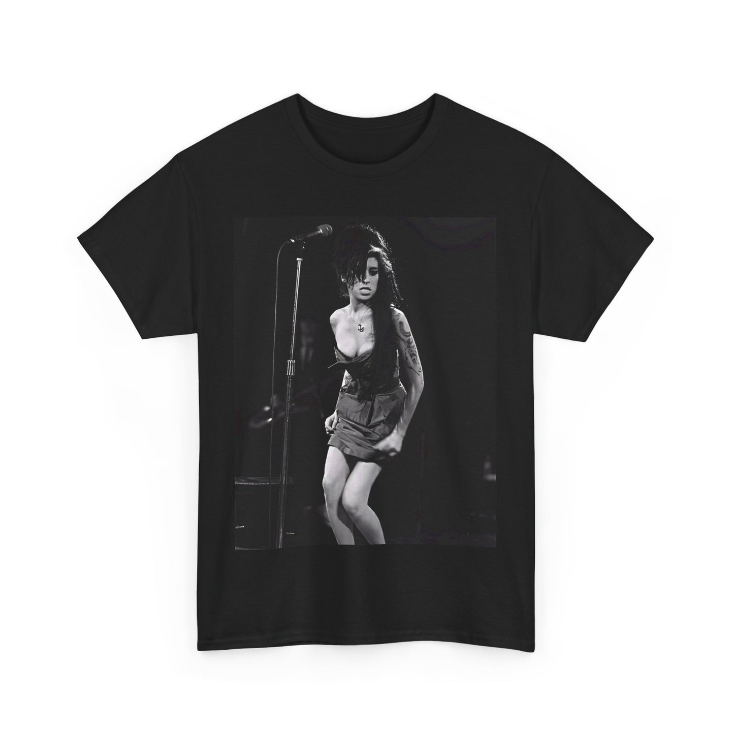 A black graphic t-shirt featuring a photo of Amy Winehouse performing live on stage at nightfall, with stage lighting effects.